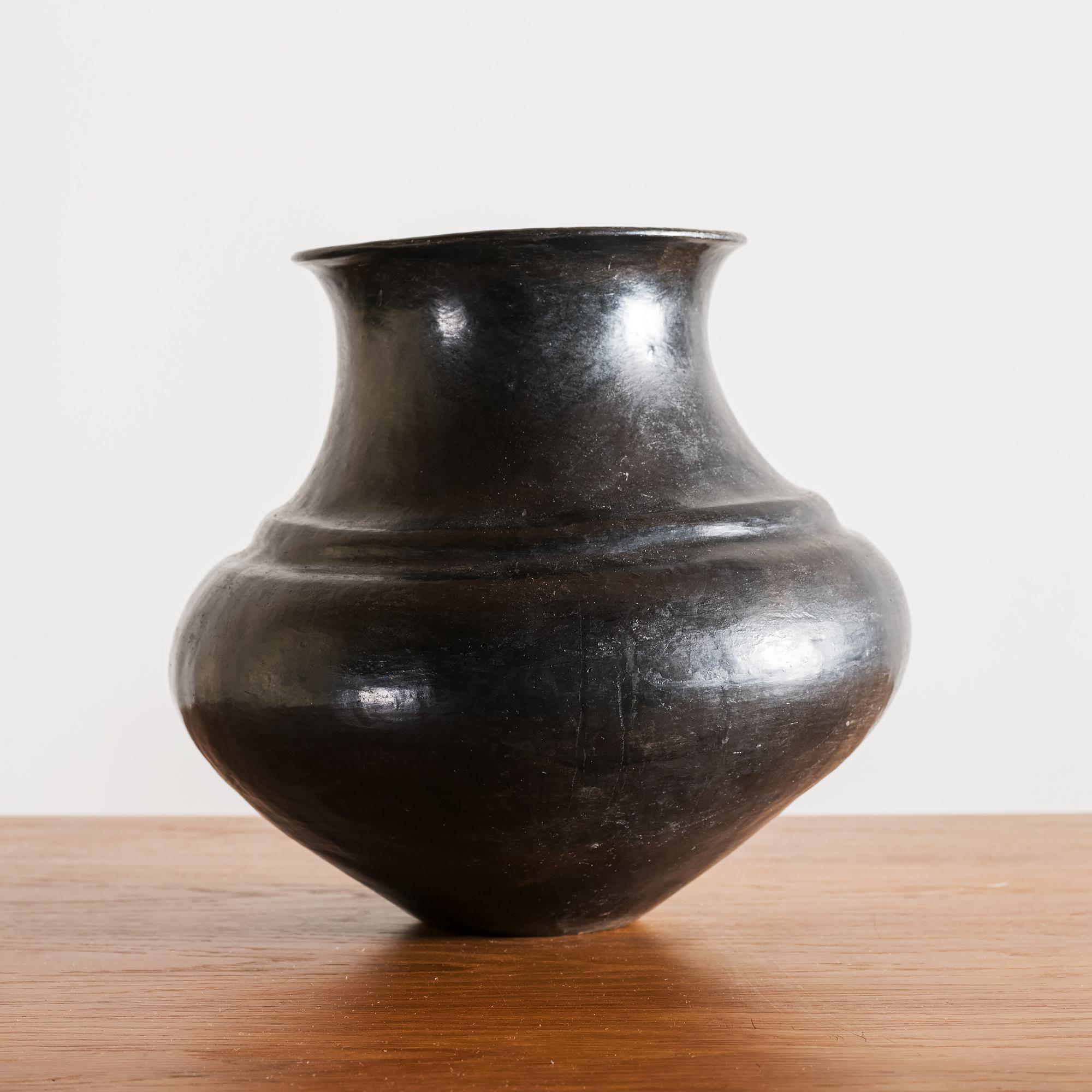 Santa Clara Pueblo blackware storage jar with a graceful, wide body and flaring rim, New Mexico, 1890s.