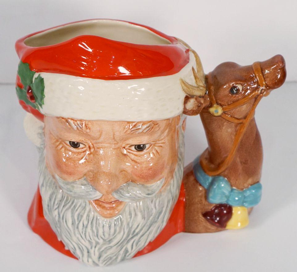 Une belle cruche ou tasse décorative vintage à l'effigie du Père Noël, de la firme de poterie anglaise Royal Doulton.

