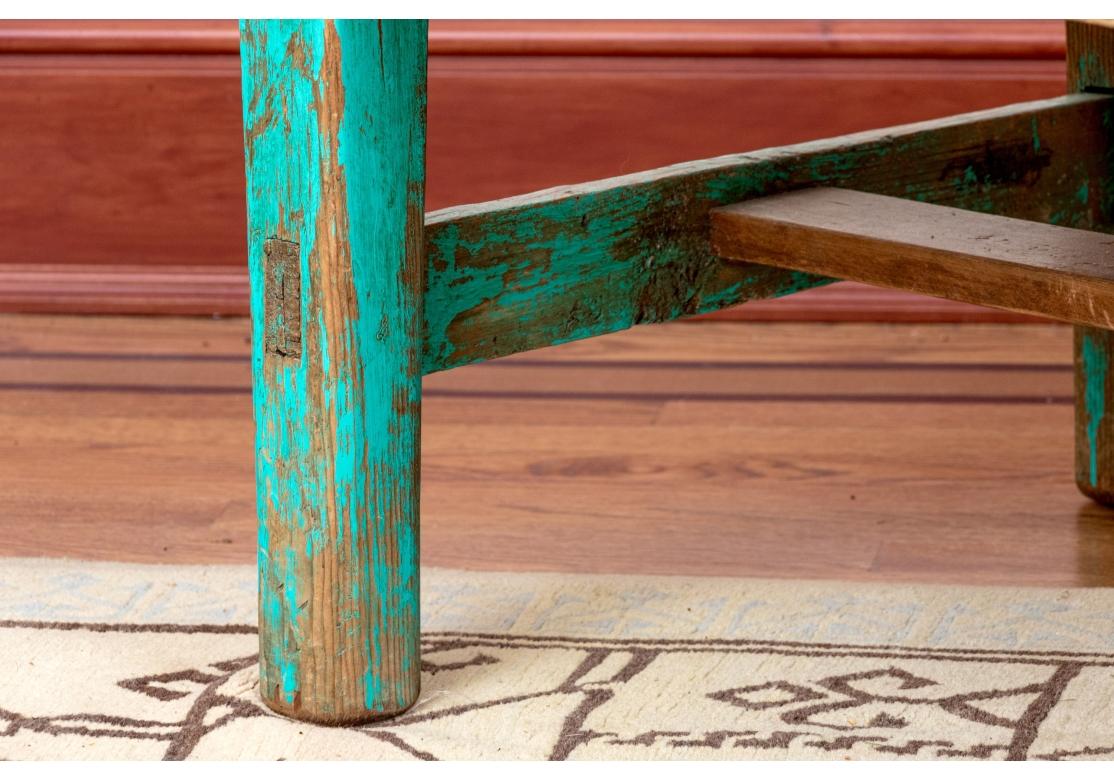 Originally acquired at the iconic New Preston Connecticut based design store J. Sykes. Originally the table was likely a kitchen work table which has been cut down. Green finished peg constructed frame on four legs with unfinished trestle stretcher