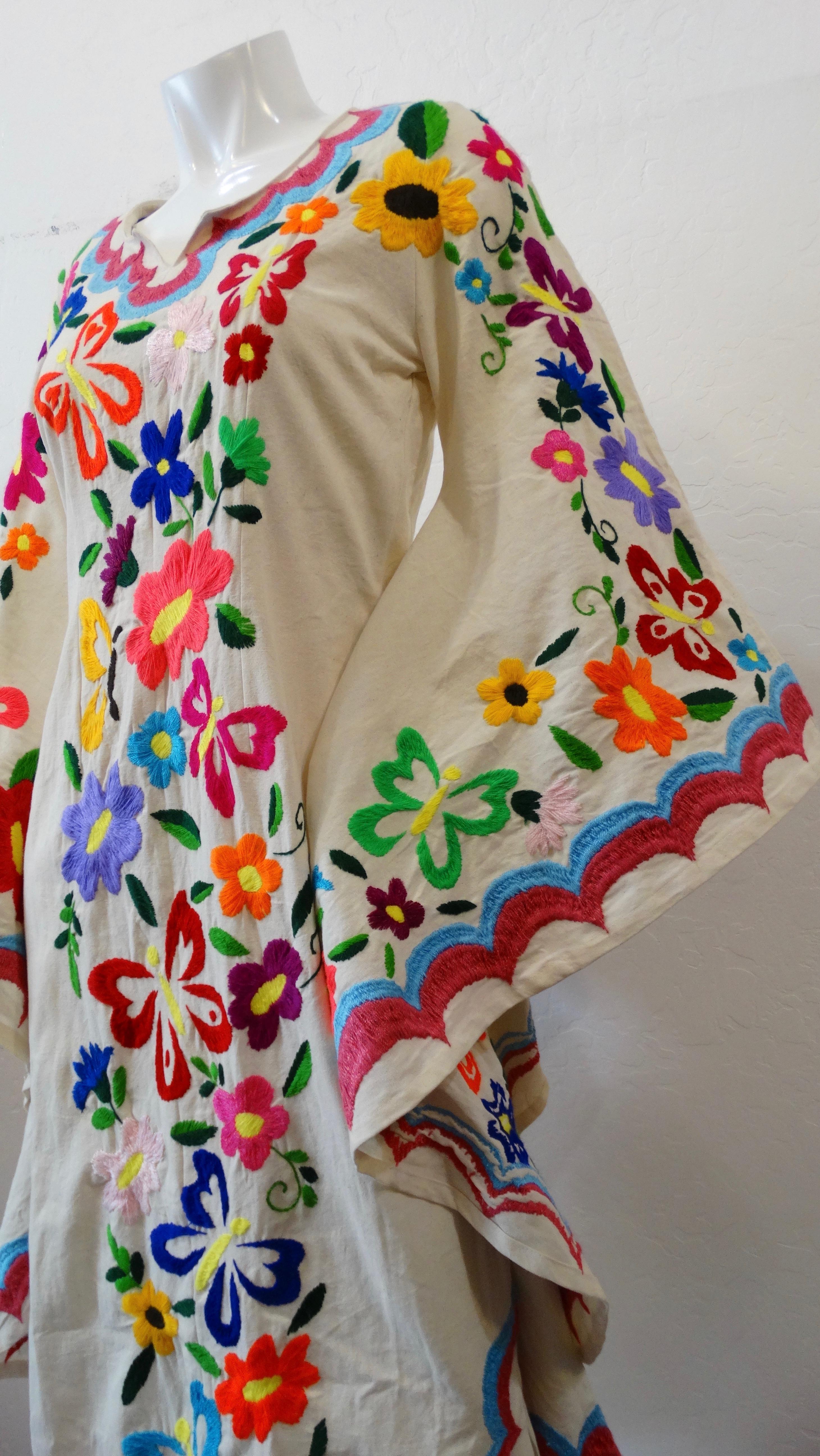 It doesn't get any more bohemian than this dress! This incredible kaftan boasts the longest angel wing sleeves we've ever seen! Covered in bright and colorful intricate floral and butterfly embroidery! Scooped neckline with notch at the center. Pair
