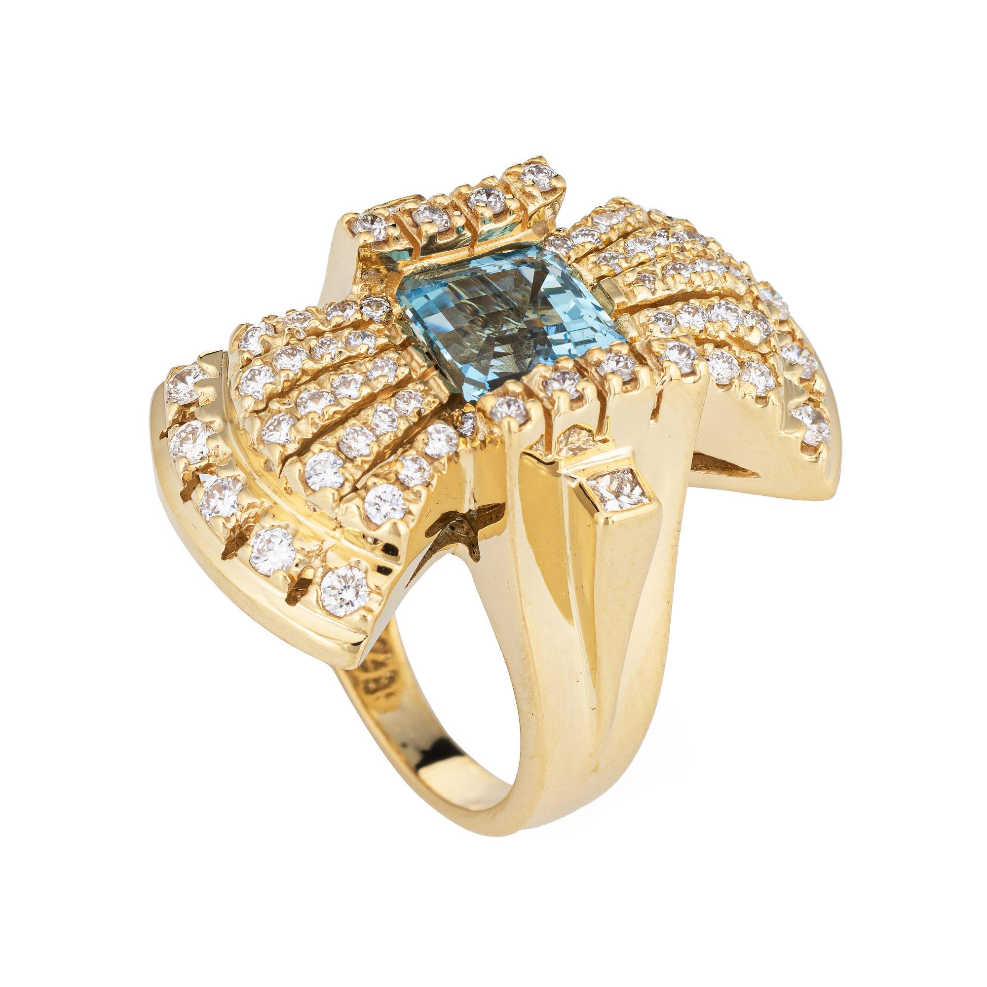 Stylish aquamarine & diamond cocktail ring (circa 2000s) crafted in 18 karat yellow gold. 

Emerald cut aquamarine measures 8mm x 7mm (estimated at 2.30 carats), accented with 60 round brilliant cut diamonds totaling an estimated 1.25 carats