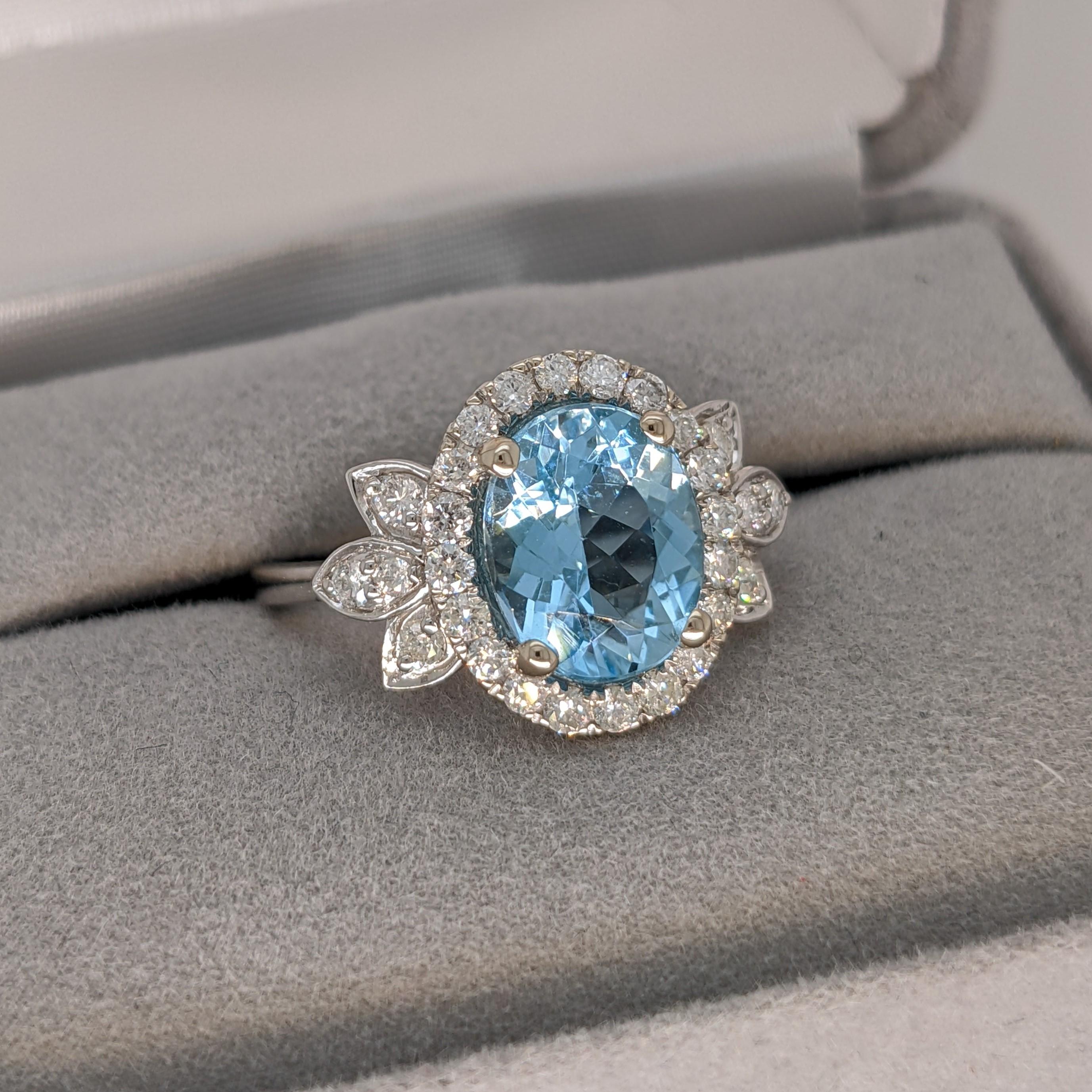 This Santa Maria Aquamarine is a 2.12 carat faceted oval cut gemstone with a gorgeous sea blue color. The ring is made in 14k white gold with diamond studded design elements on either side of the center stone. This ring has a halo of natural earth