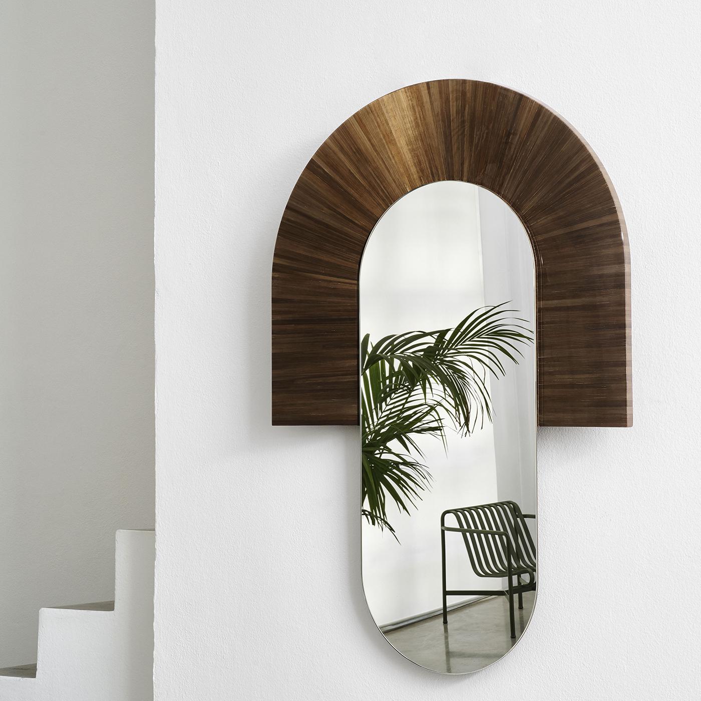 Reflect on your day in peace with the Santa Mirror by Marco Sorrentino. Framed in divine straw marquetry in glistening dark gold tones, the oval mirror can also help brighten up a dark hallway or corner. The mirror is available in pink, gray and