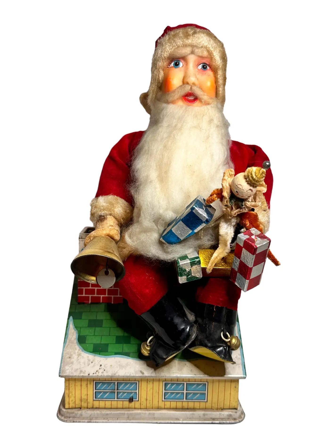 Gorgeous vintage sheet metal, plastic and fabric made money bank. Operated by switch or upon deposit of coins. Functions include - flashing eyes, head moves left-right, arms move up/down and bell rings. Santa holds small foil-wrapped Christmas