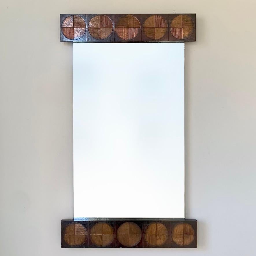 Magnifique miroir mural de Sant'ambrogio & De Berti, circa 1960, Italie. 
Cuivre gaufré sur bois avec un joli motif rond, miroir d'origine.
Label original au dos. Rare pièce de collection en bon état.
Dimensions : 104 cm H, 60 cm L, 4 cm P.
Tous les