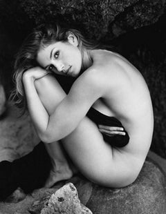 Cindy Crawford - black & white nude portrait of the supermodel sitting on a rock