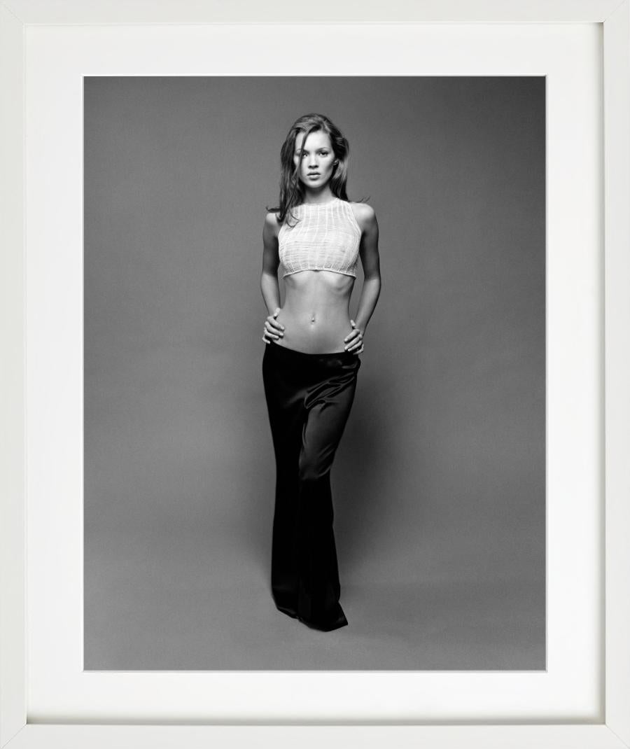 A black-and-white fashion portrait of the famous supermodel Kate Moss in a white crop top and black silk skirt. Photographed by Sante D'Orazio in the West Village in 1992.

All prints are limited edition. Available in multiple sizes. High-end