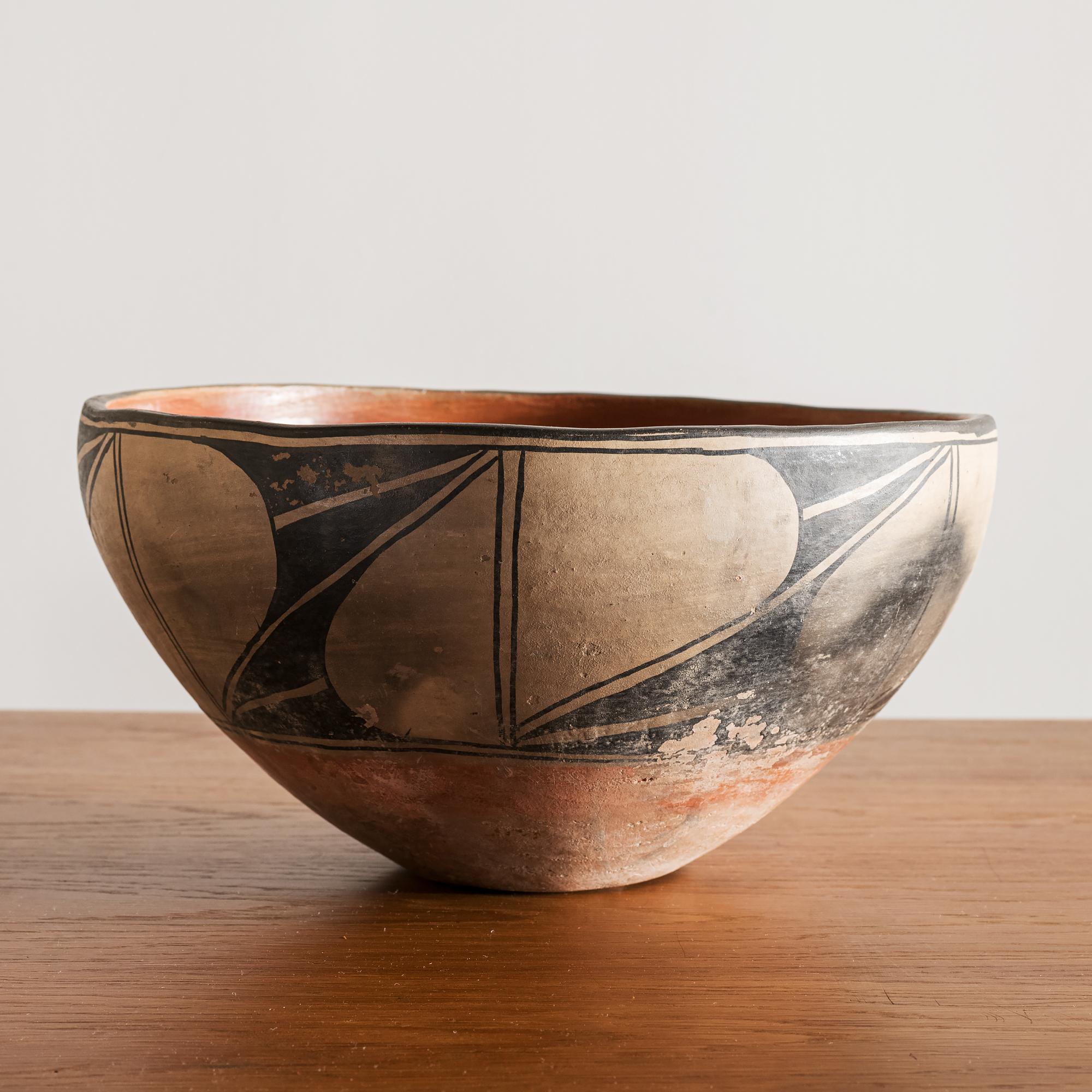 Santo Domingo pueblo dough bowl in black vegetal paint over cream-colored slip, circa 1900. Lovely exterior patina indicating extensive domestic use.