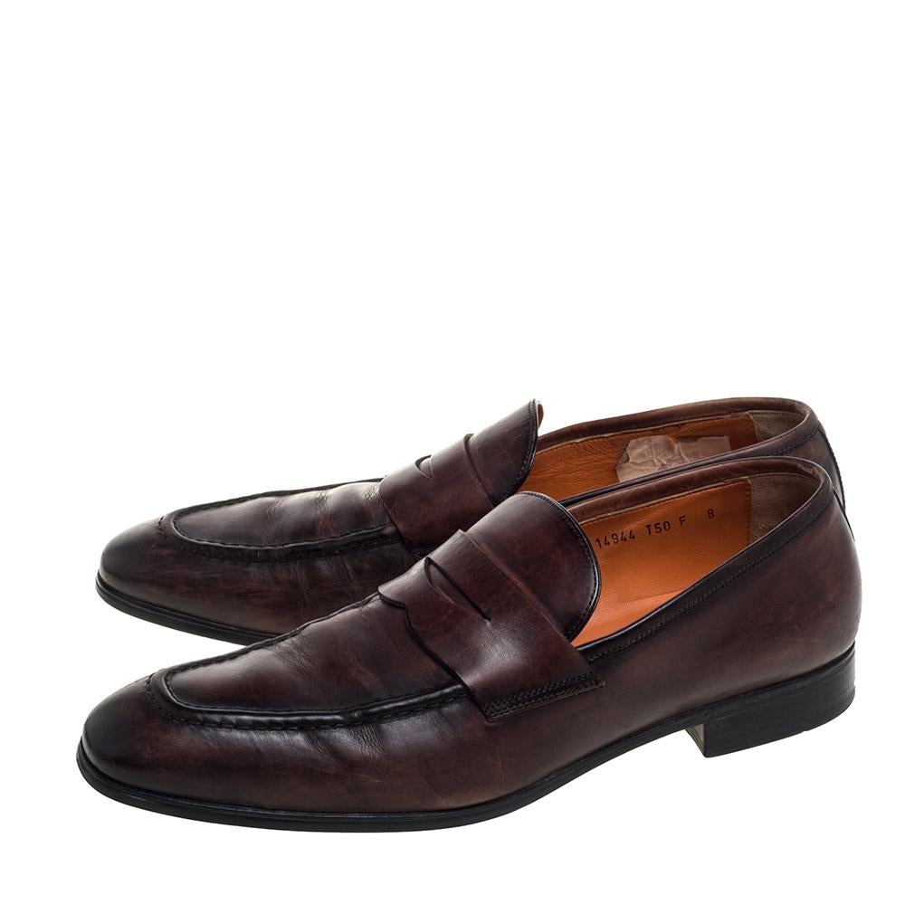 Keep it minimal yet classy in these brown slip-on loafers from Santoni. They are crafted from leather and styled with Penny keeper straps on the vamps. They come equipped with comfortable leather-lined insoles and will look great with your formal