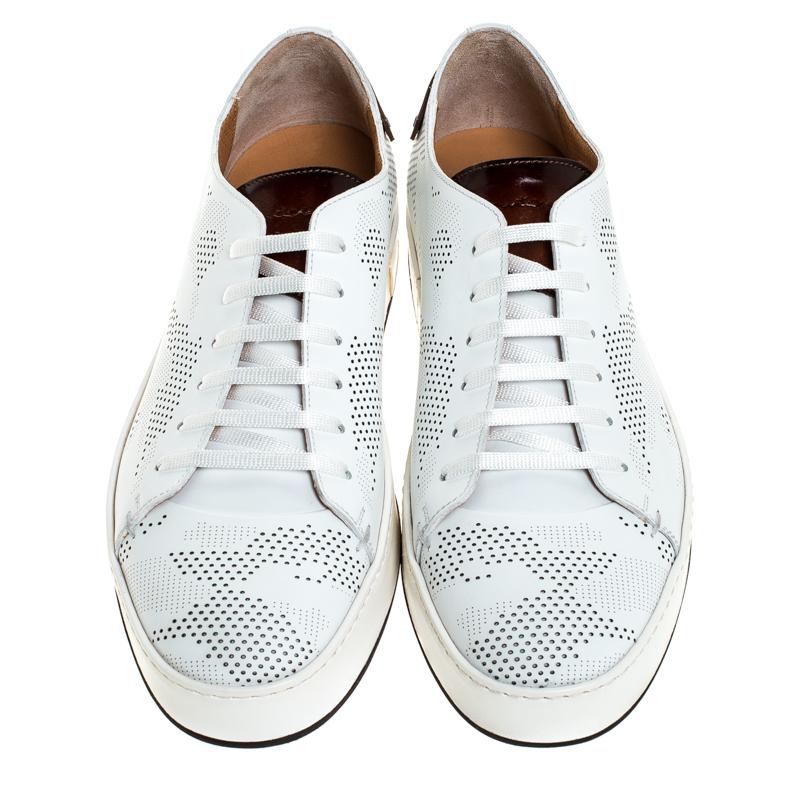 Let your latest shoe addition be this pair of white sneakers from Santoni. They've been crafted from perforated leather and styled with lace-ups and simple round toes. They are complete with contrast leather tabs on the counters and rubber