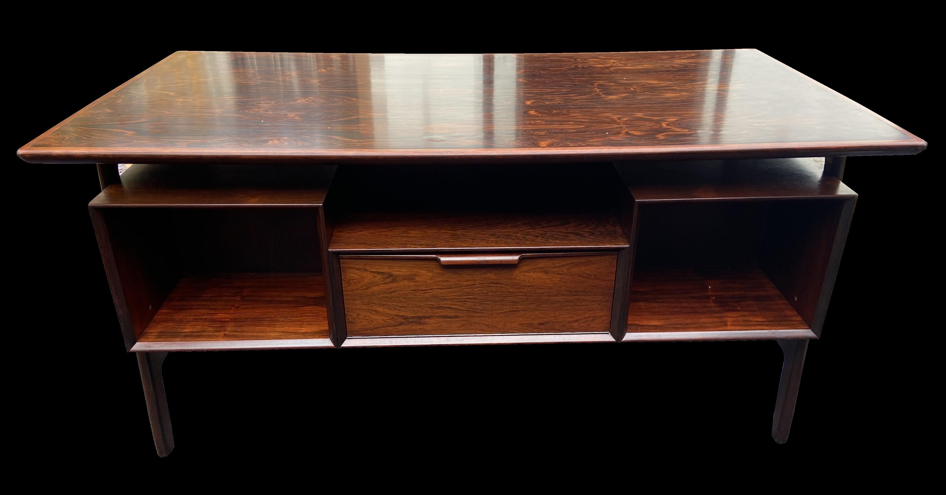 A very nice desk with six drawers on one side and open book/file shelves on the back flanking a drop down flap, in Santos Rosewood (a species that does not require a cites certificate to import or export), designed by Gunni Omann for Omann Junn