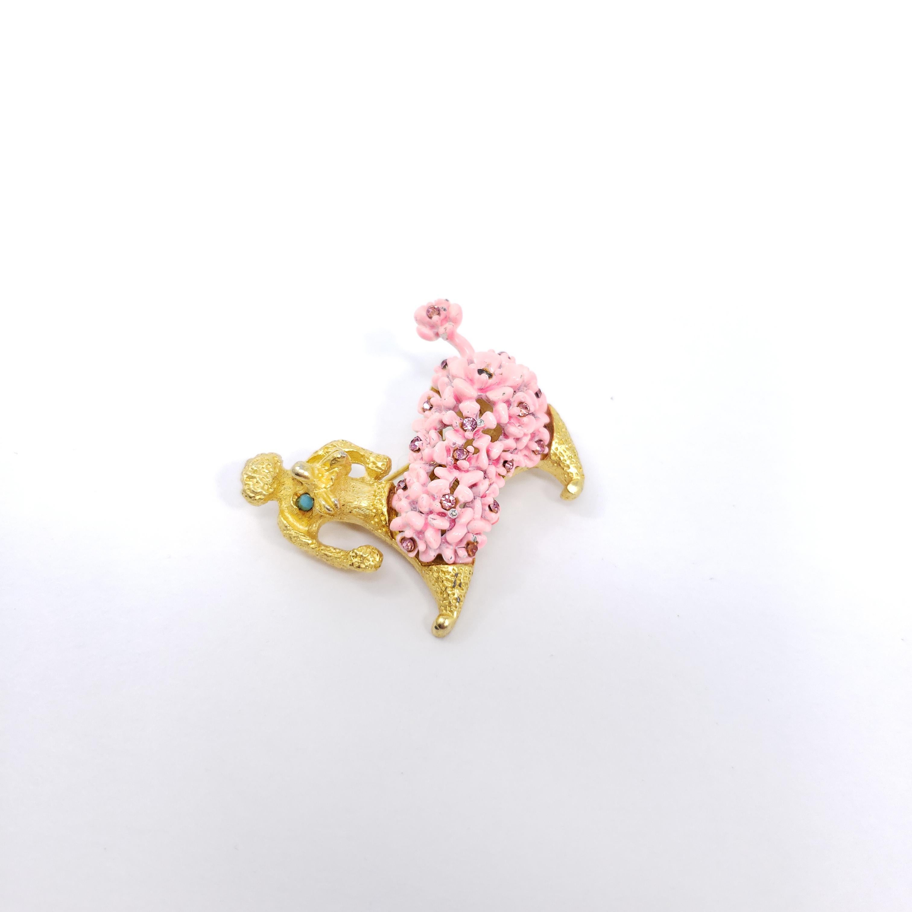This perky golden pup is decorated with pink-enamel flowers, crystals, and turquoise-colored cabochons. Vintage pin / brooch.

Gold-tone.

Marks / hallmarks / etc: SAO