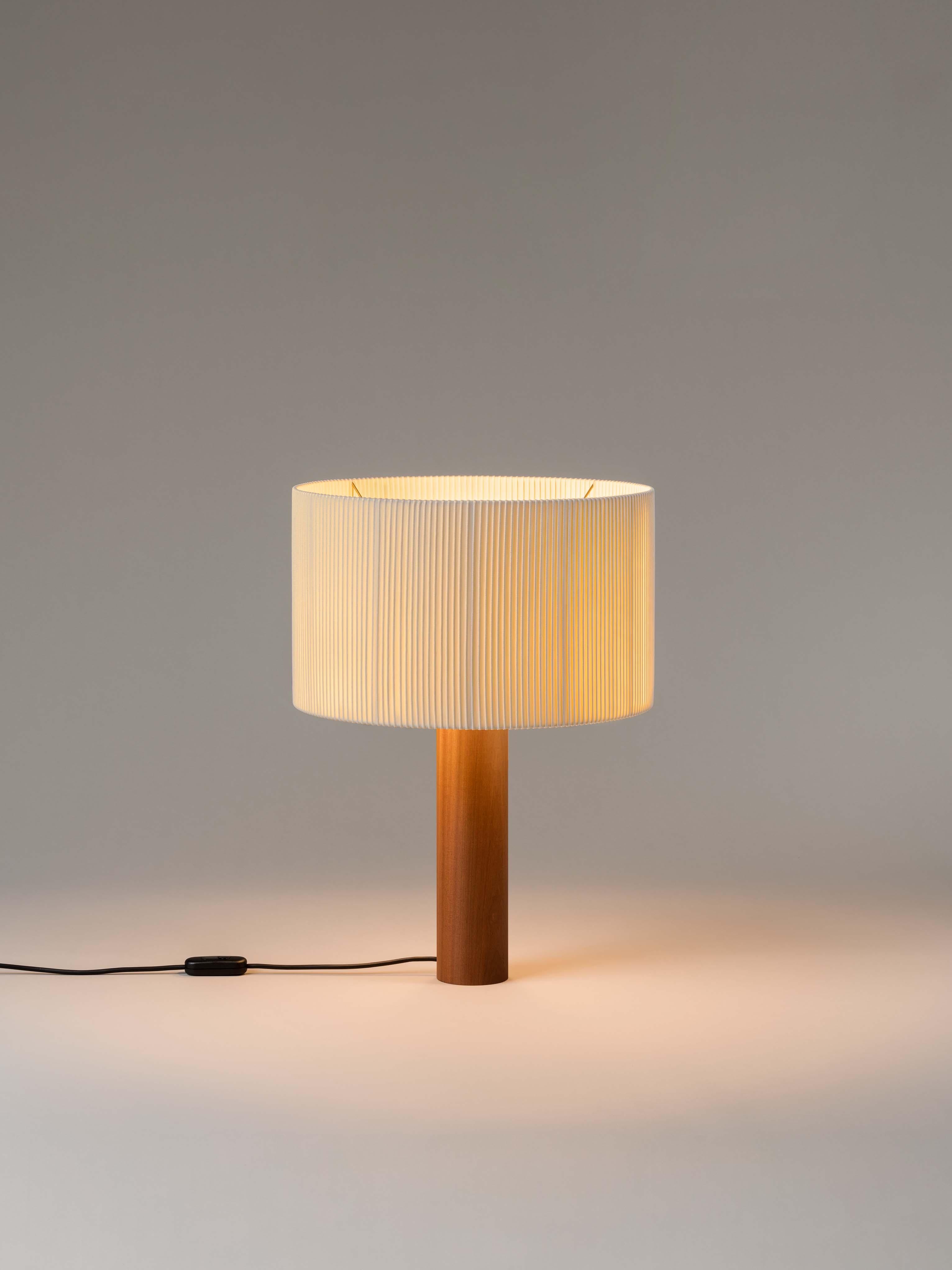 Sapeli Moragas table lamp by Antoni de Moragas Gallissà
Dimensions: D 45 x H 62 cm
Materials: Sapeli wood.
Available in sapeli or oak wood.

A sturdy wooden cylinder supports a head with three bulbs, surrounded by a generous circular shade. The