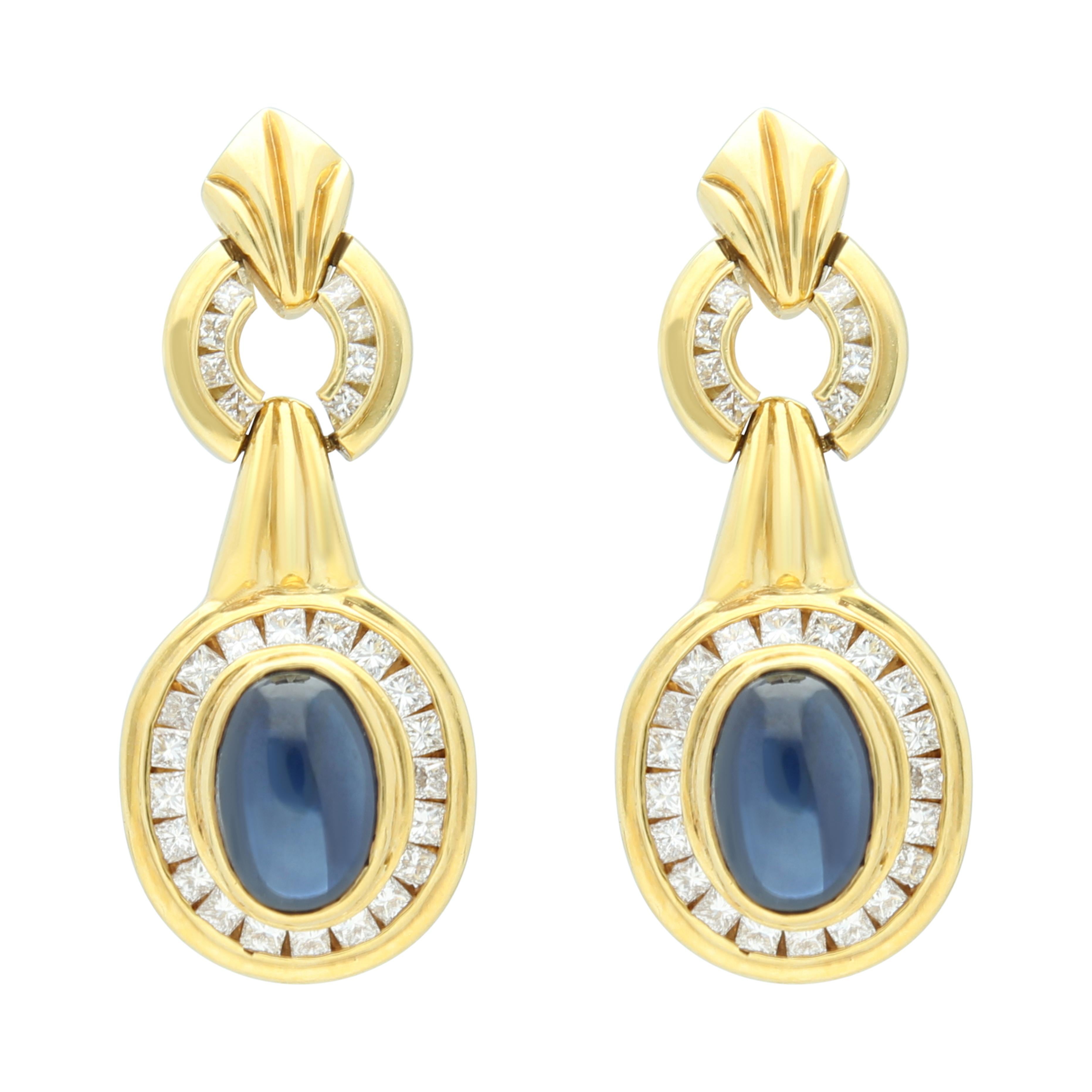 a pandant collect-set with a cabochon sapphire, framed by squarediamonds, to a gold link, length approxiamately 420mm, a ring, size 5, and a pair of pendent earings of similar desighn, post and butterfly fitting.
