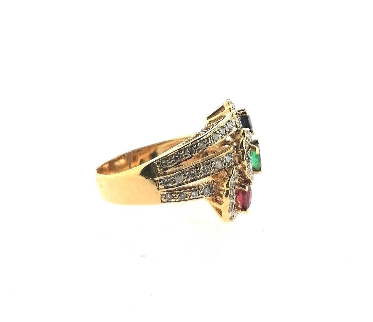 A 18 karat yellow gold ring with three oval colored stones of 0.25 carats each one:
A sapphire, an emerald and a ruby. Brilliant-cut diamonds totaling 1.00 carat in weight are set around the colored stones. It is a very elegant wide ring with a very
