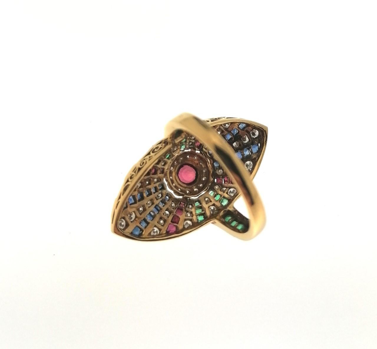 Very showy and colorful 1970´s oval ring in 18 Karats Yellow Gold with a Central Ruby of 0.08 Carats. Around it converge several lines of Sapphires, Rubies, Emeralds and Diamonds.
It also has Emeralds Size Carré on the ring. It has an Exceptional