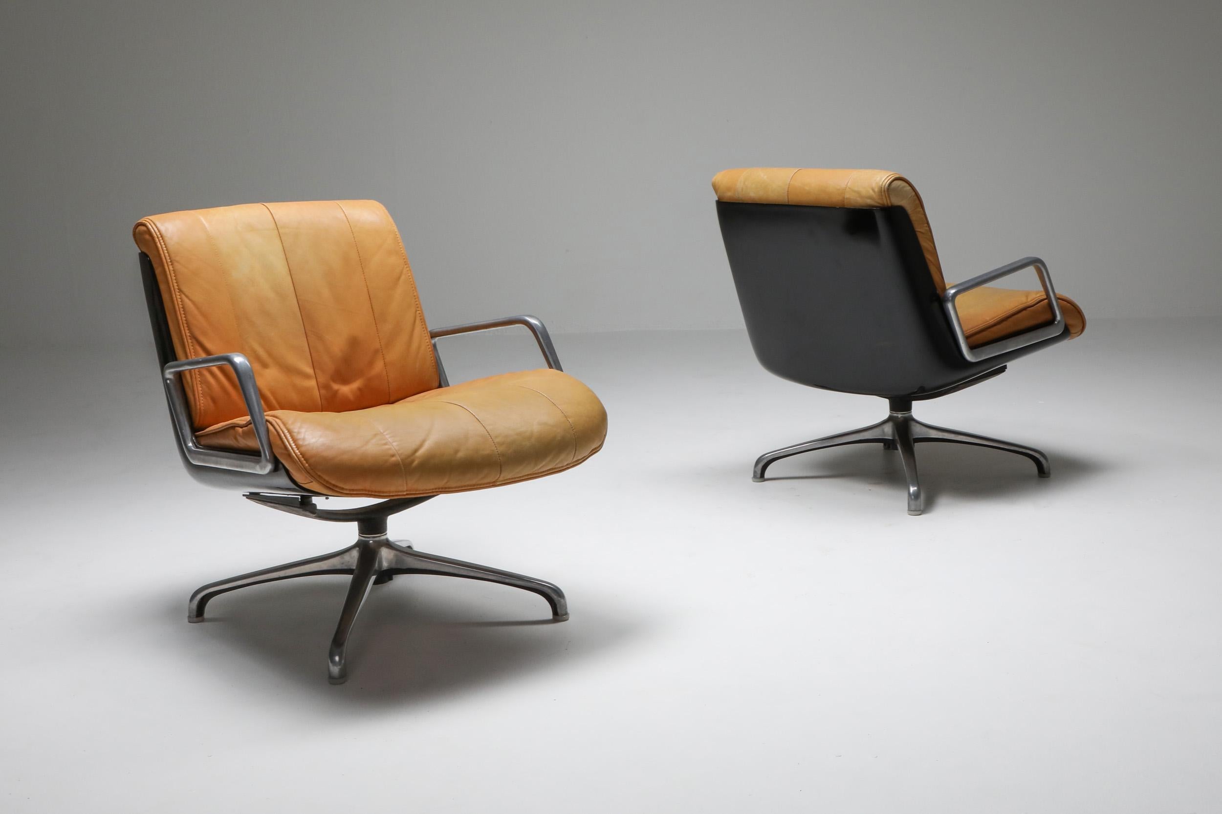 Postmodern swivel lounge chairs made by Saporiti, Italy, 1970s.

Nude or camel leather seating, aluminum armrests and base, black resin back.
Saporiti Italia was known for it's highest quality and very expensive designer pieces.
      