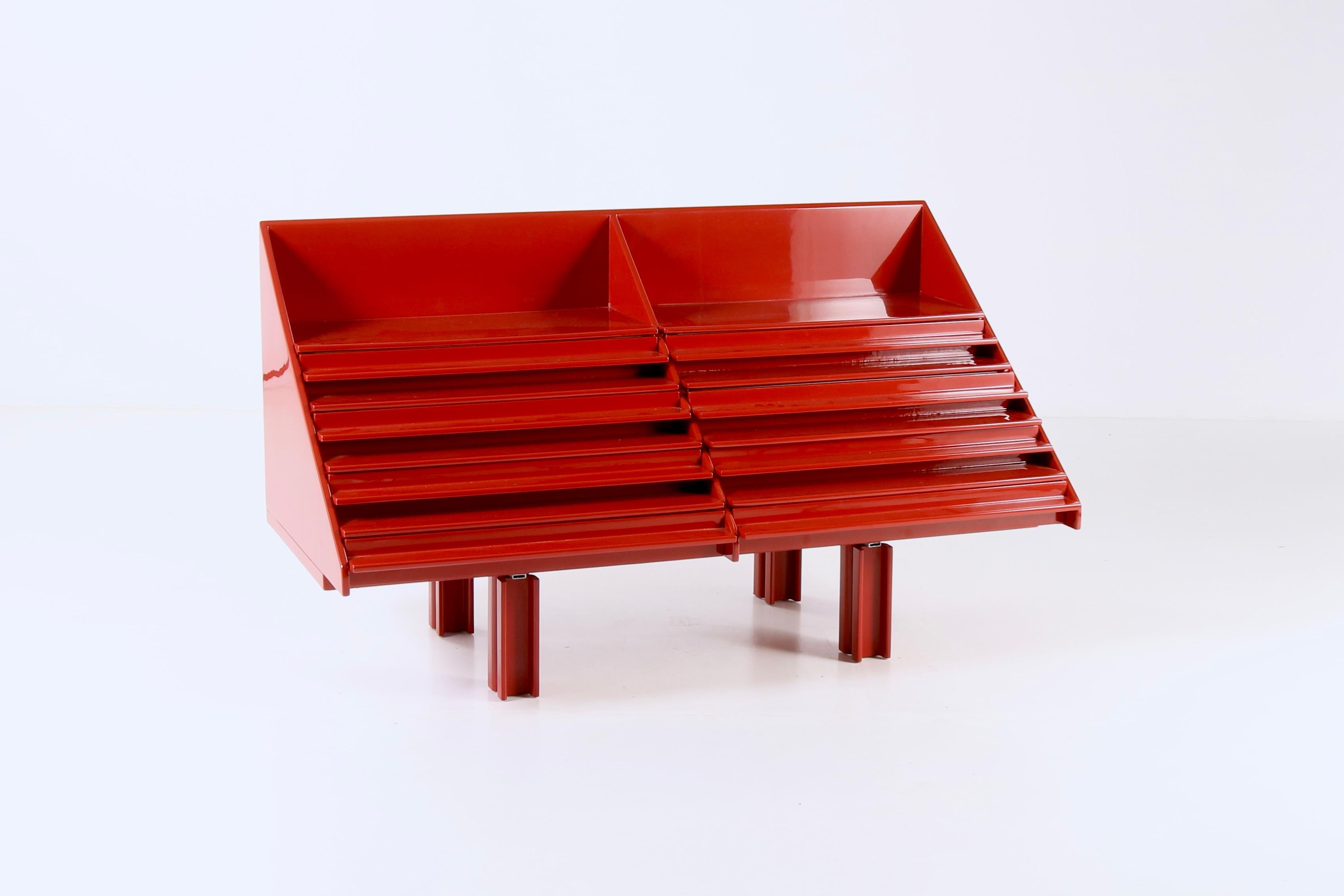 Indulge in timeless sophistication with this exquisite Saporiti's 1970s storage furniture with drawers. Its idiosyncratic shapes and vibrant tint in red makes it a iconic interior that can fit any refined space or ambience. It blends functional art