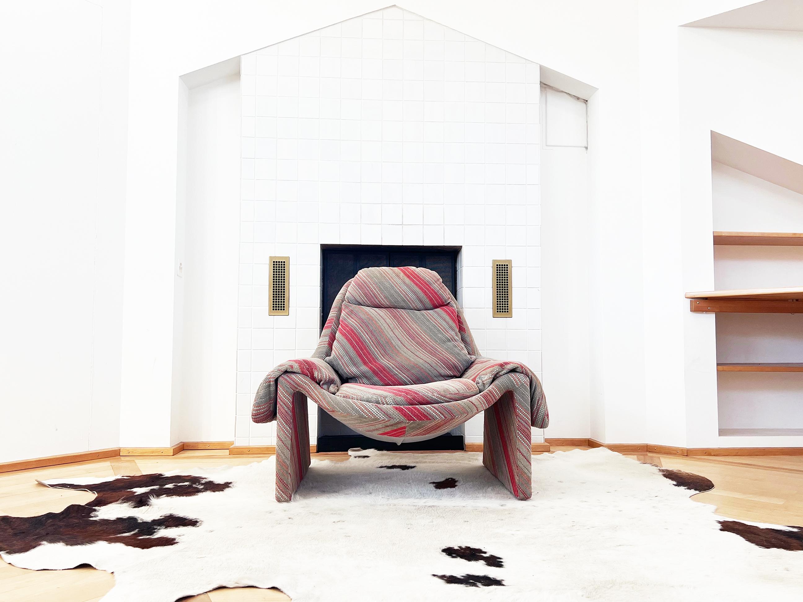 Un conjunto de sillón impresionante y excepcionalmente cómodo con un precioso tejido de diseño Saporiti de rayas originales y un reposapiés a juego que refleja las curvas del sillón. Este conjunto presenta su tapicería original en muy buen estado.