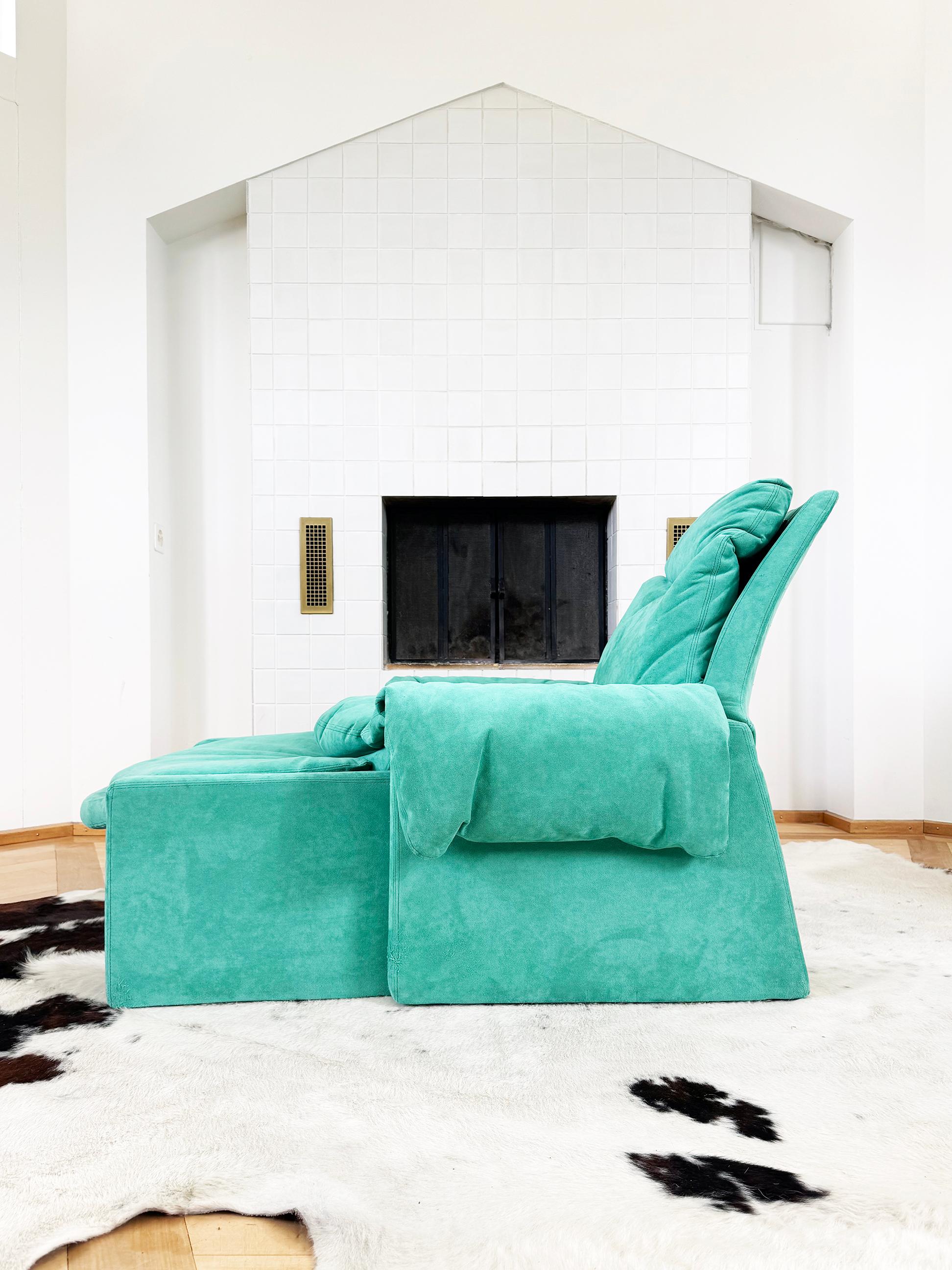 Un impresionante y excepcionalmente cómodo conjunto de sillón con un precioso e increíble textil de diseño Saporiti de ante turquesa original y un reposapiés a juego que refleja las curvas del sillón. Este conjunto presenta su tapicería original en