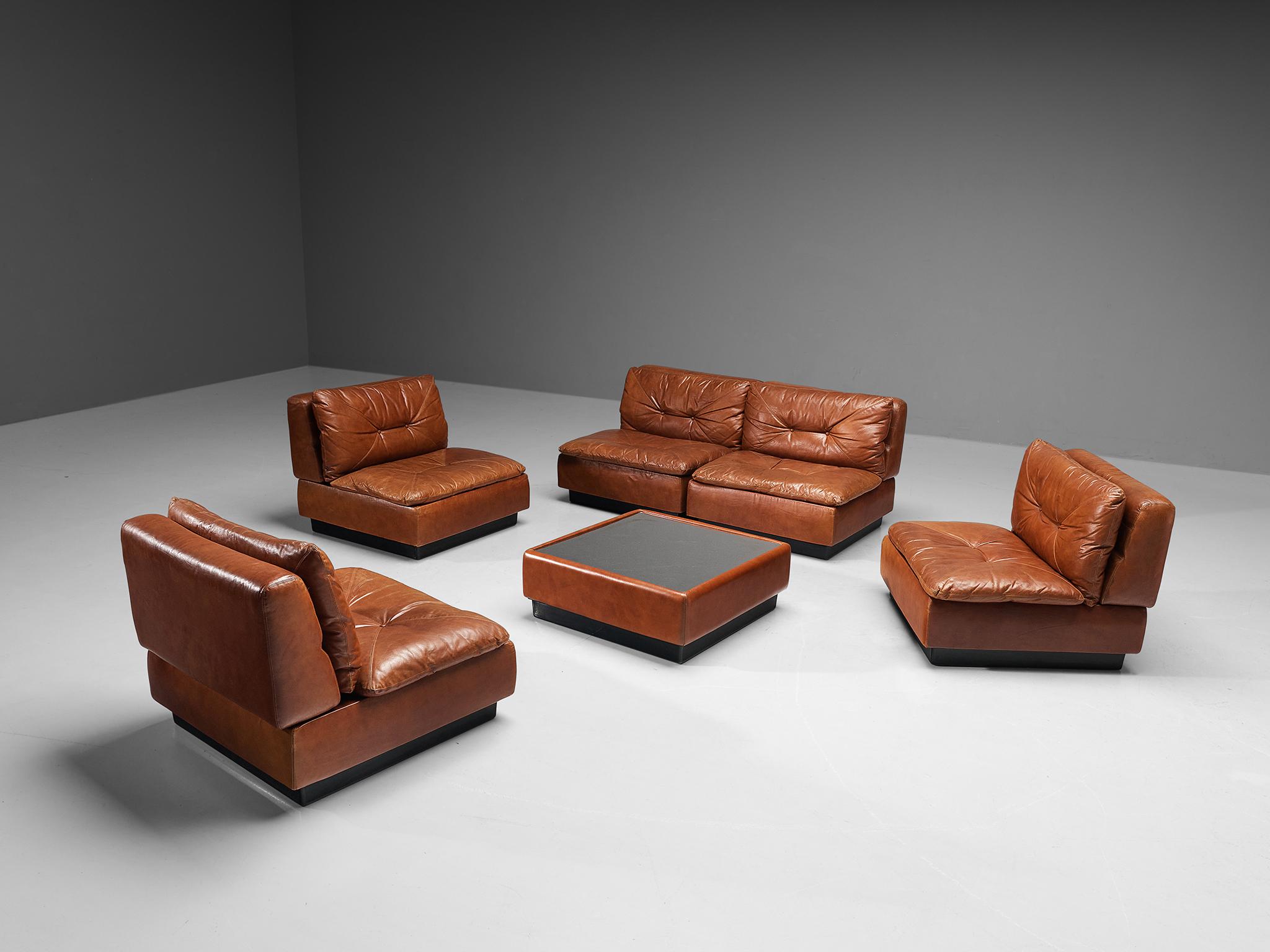 Saporiti, modular sofa with 5 elements and coffee table, cognac leather, metal, Italy, 1970s. 

This well-designed sectional sofa manufactured by Saporiti in the 1970s is fully executed in beautiful cognac leather that contributes to the whole