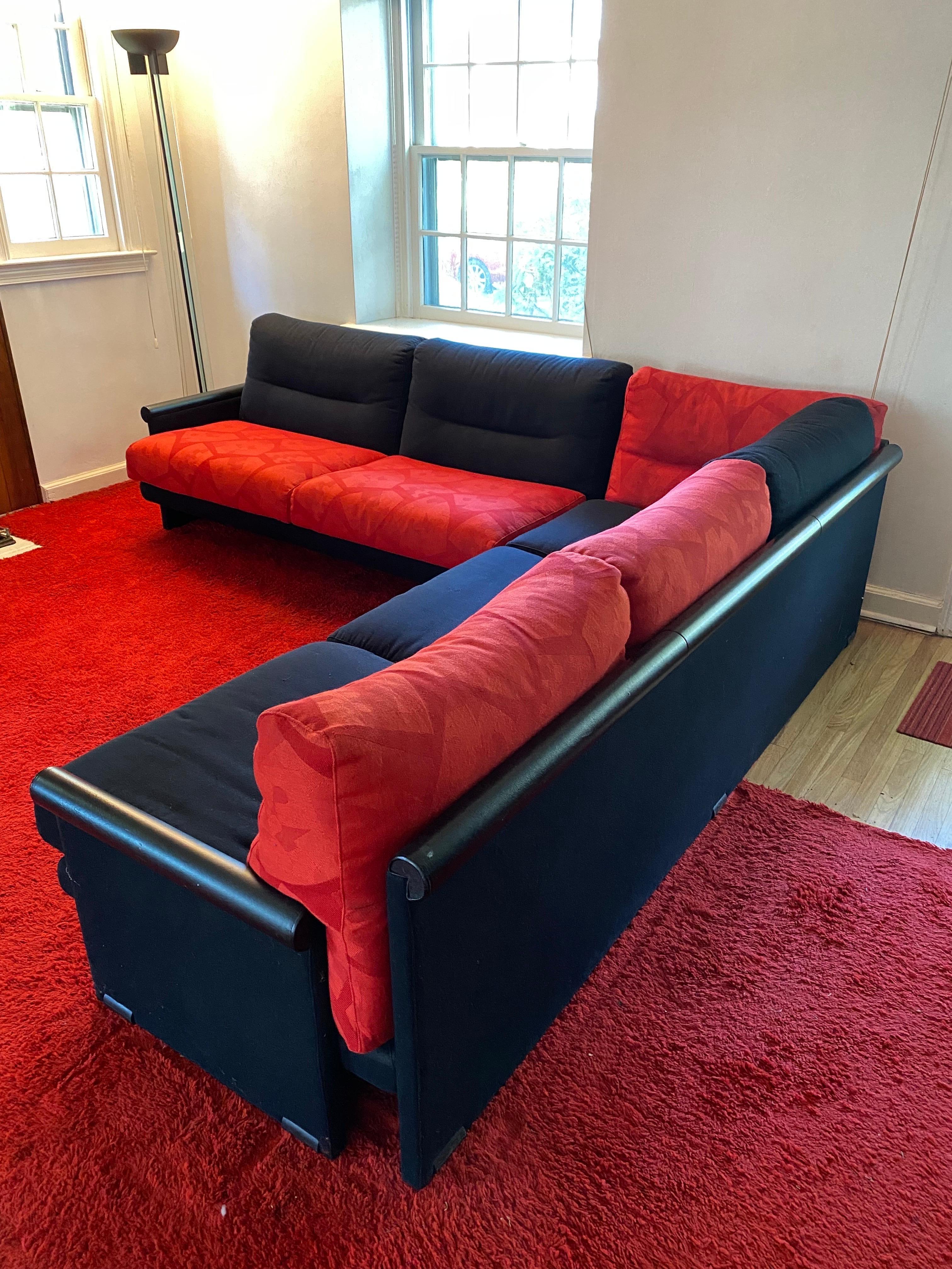 Saporitti Sectional Sofa. Dates to the early 1980's. In very nice original condition. 
 Always in a Dark Living Room so no signs of fading. Black leather arms with black fabric backs. Would be very easy to reupholster just the seat cushions if red