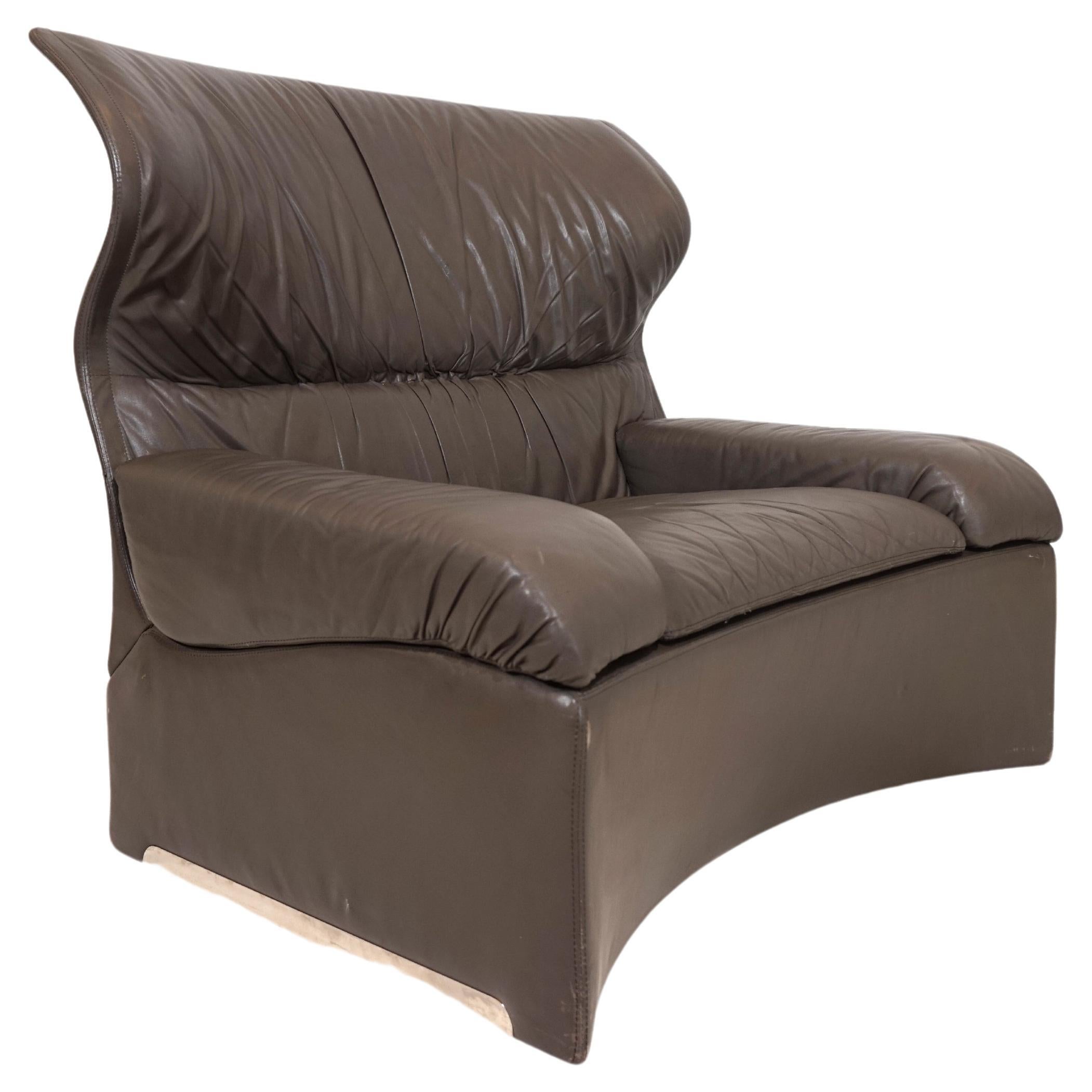 This large gray leather armchair comes in very good condition. The soft leather of the armchair and the ottoman shows slight signs of wear. The pure dimensions of the chair offer a high level of seating comfort. The chrome feet of the Ottoman are in