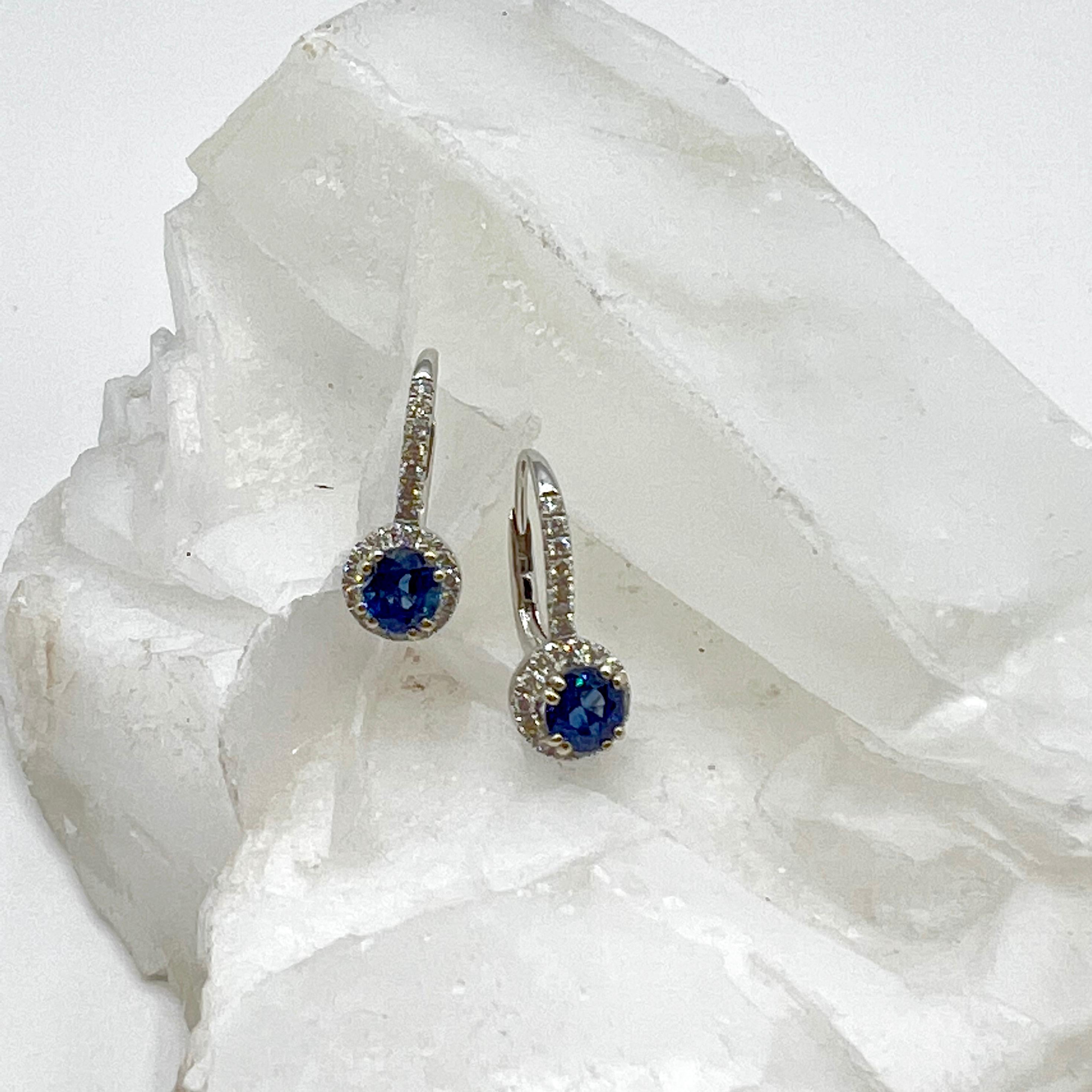 These stunners have deep blue round  natural sapphires with a total carat weight of 1.15. The surrounding bright white natural diamonds are a total carat weight of 0.34 to create a beautiful contrast. The leaver backs have diamonds vertically for a