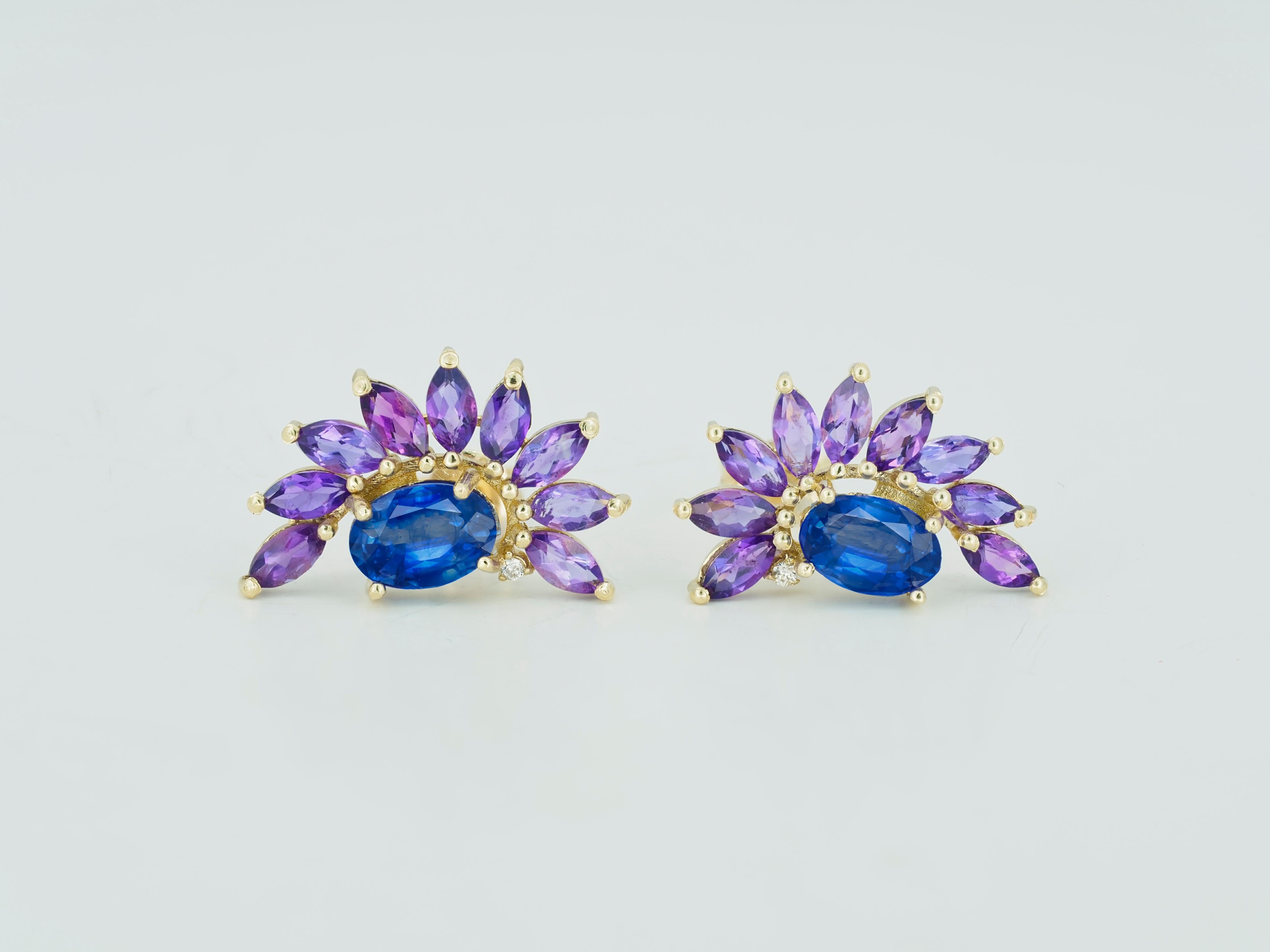 Sapphire 14k gold earrings studs. 
Amethyst earrings studs. Sapphire and amethyst in 14k gold earrings studs. Genuine sapphire earrings.

Material: 14k gold.
Weight: 2.3 gr.
Size Earrings: 10x16.6mm.

Central stones: Natural Sapphire - 2 pieces