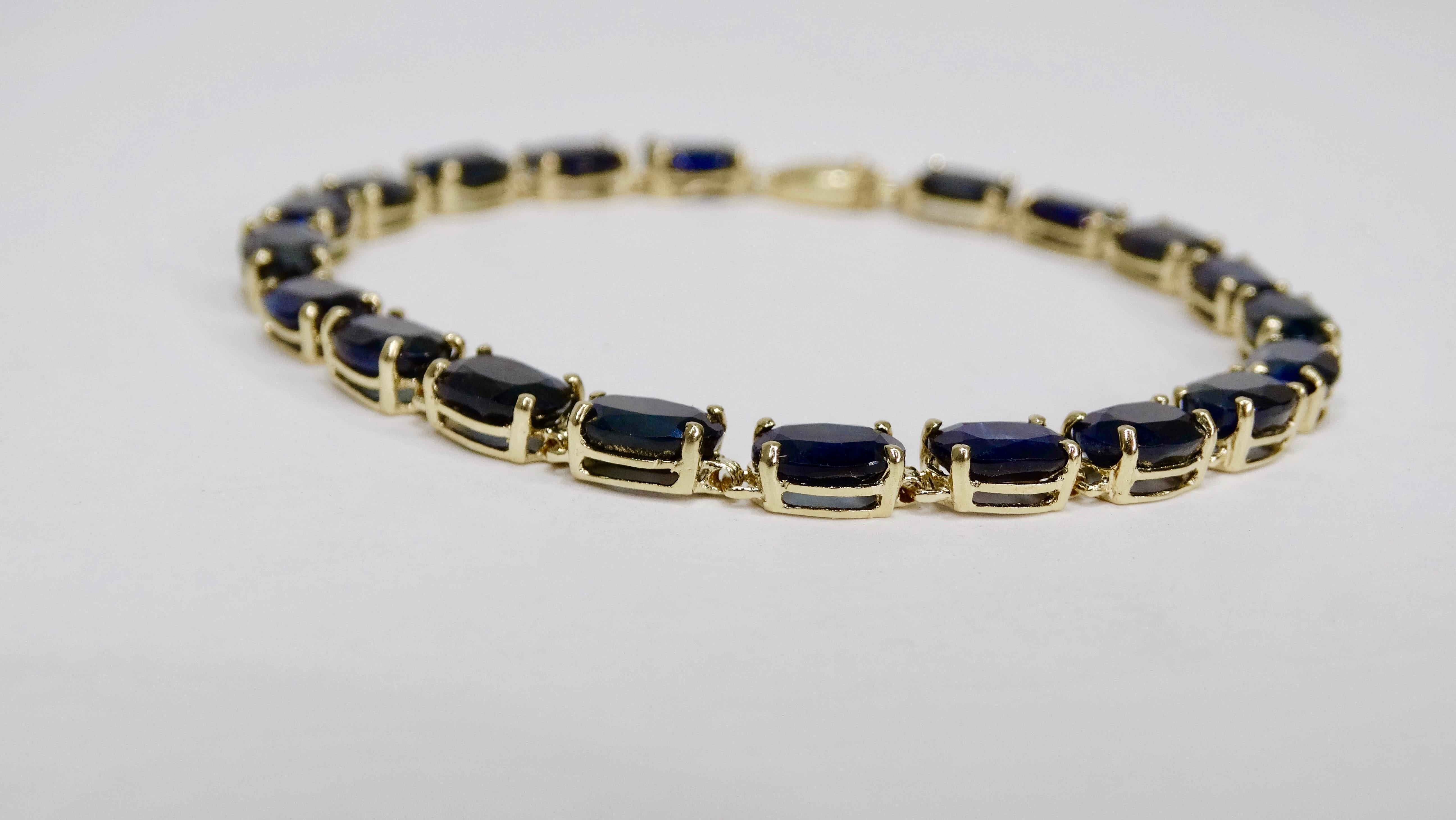 Elegant and timeless, this mid-20th century tennis bracelet is crafted from 14k gold and features 20 1ct oval cut Sapphires (20ct total) set in a prong setting with a tab closure and security clip. Weighs 9.11g in total weight. Wear day to day or