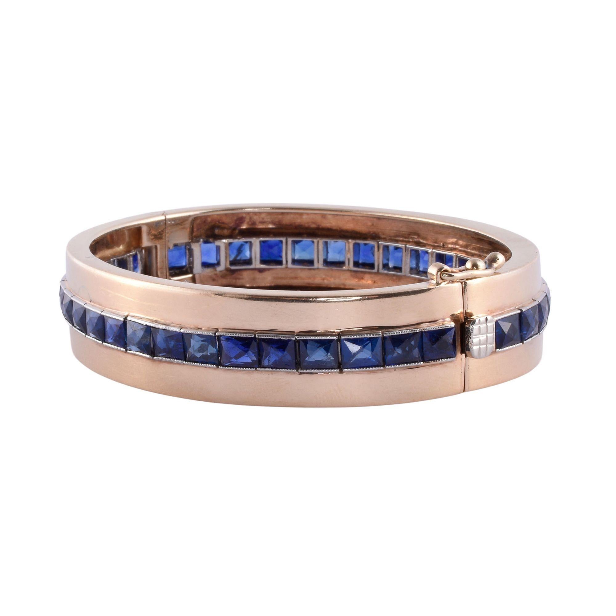 Vintage sapphire 14K & platinum hinged bangle bracelet, circa 1930. This custom made bracelet is crafted in 14 karat yellow gold and platinum bar set with 38 French cut sapphires at 13.25 carat total weight. These sapphires are eye clean and very