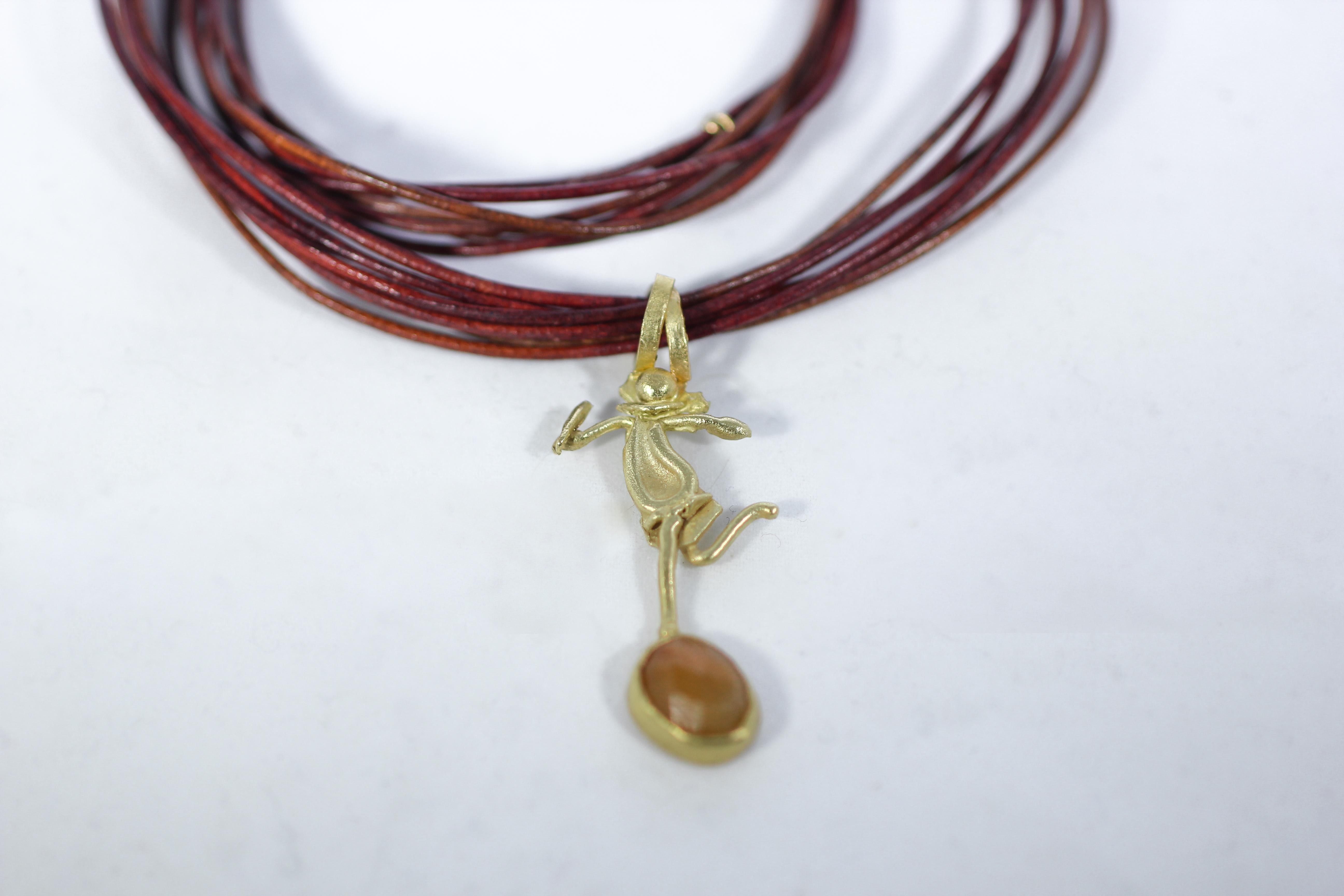 Dance pendant in 18K gold on leather multi-strand rope choker ending with an 18K gold handmade toggle clasp. 18K gold dancing figure with a rose-cut sapphire set in a bezel. Also, pictured together with He pendant. Whimsical, modernist style,