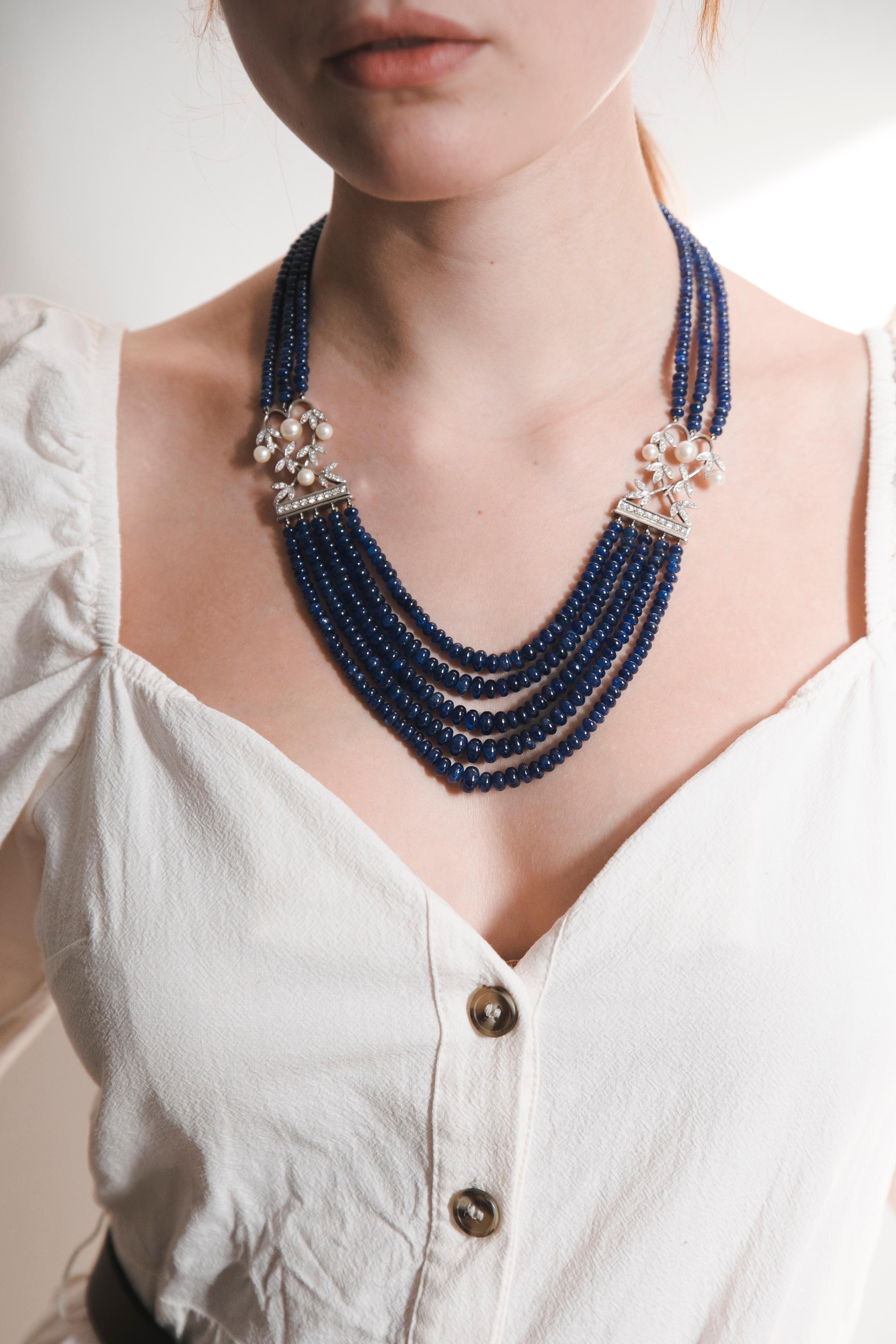 Very high-quality shiny Sapphire beads. Fine necklace with three rows of Sapphires from the back meeting the floral motif locks with Pearls and Diamonds, continuing with five rows of Sapphires degradé style. 
Sits perfectly on the figure. 
Total