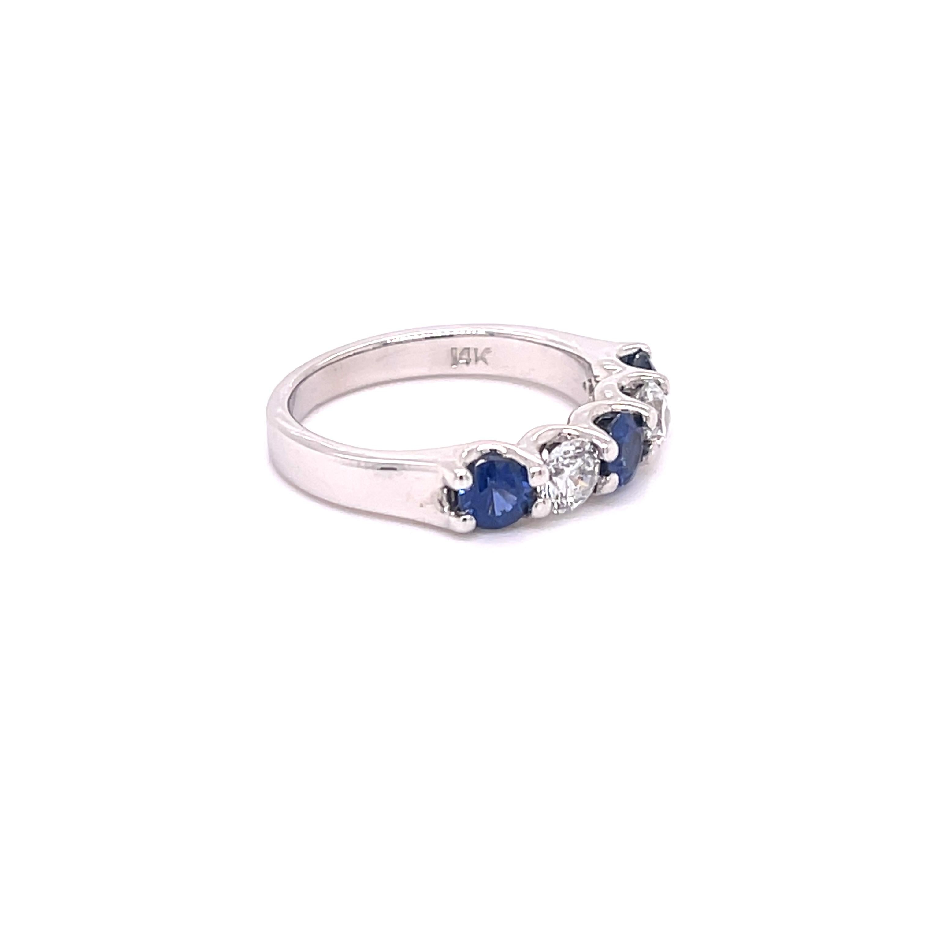 Sapphire and diamond band in 14K white gold. The band features 0.77ctw of round sapphires and 0.50ctw of round diamonds. Size 5.75, can be sized. Stamped 14K.