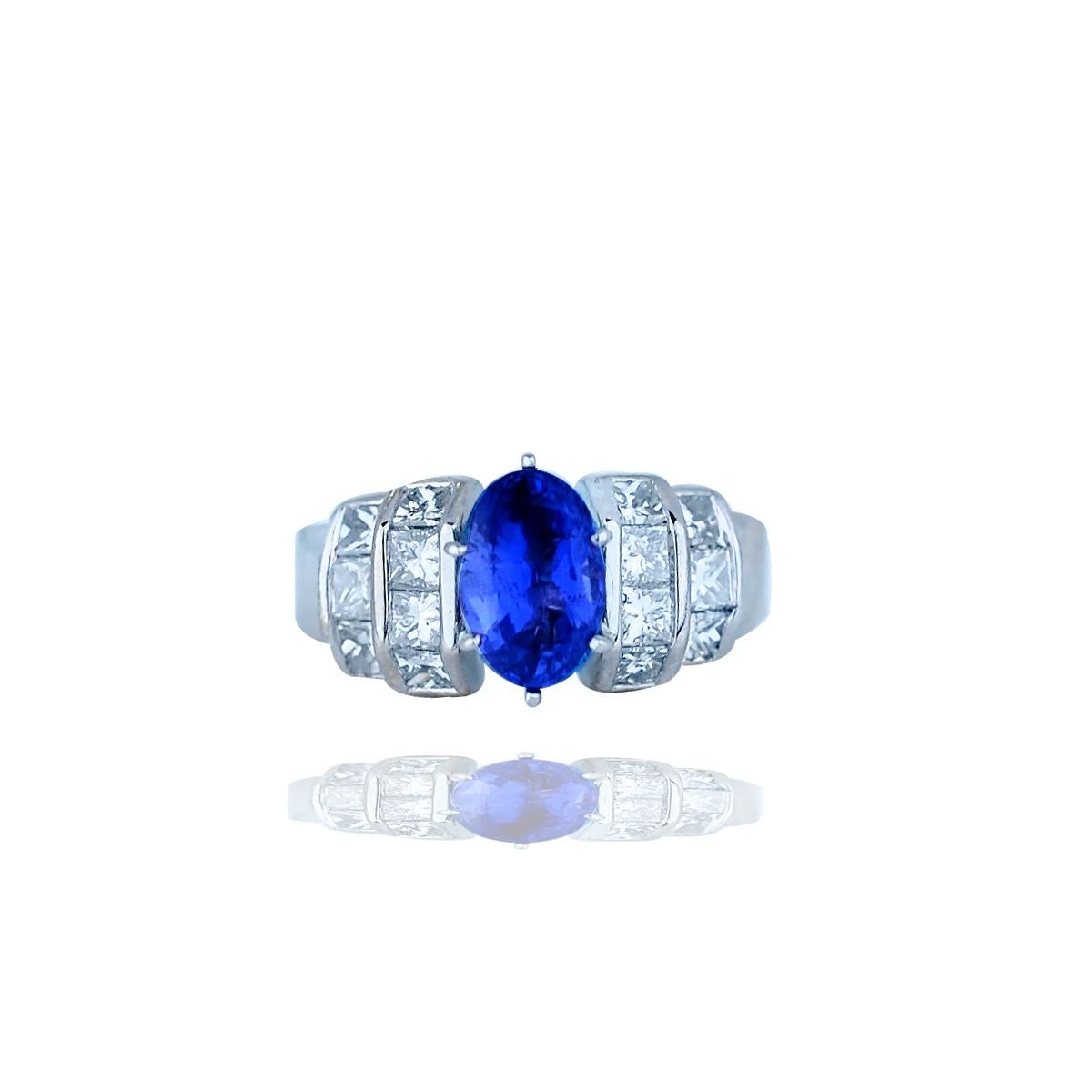 Sapphire and Channel Diamond, Baguette, Ring 18 Karat, 3.35TCW 
Center oval shaped blue sapphire measuring 9.20 x 6.08 x 4.80 mm with an estimated weight of 2.35 carats. 
Diamonds set in double rows on either side (14) princess stones have a total