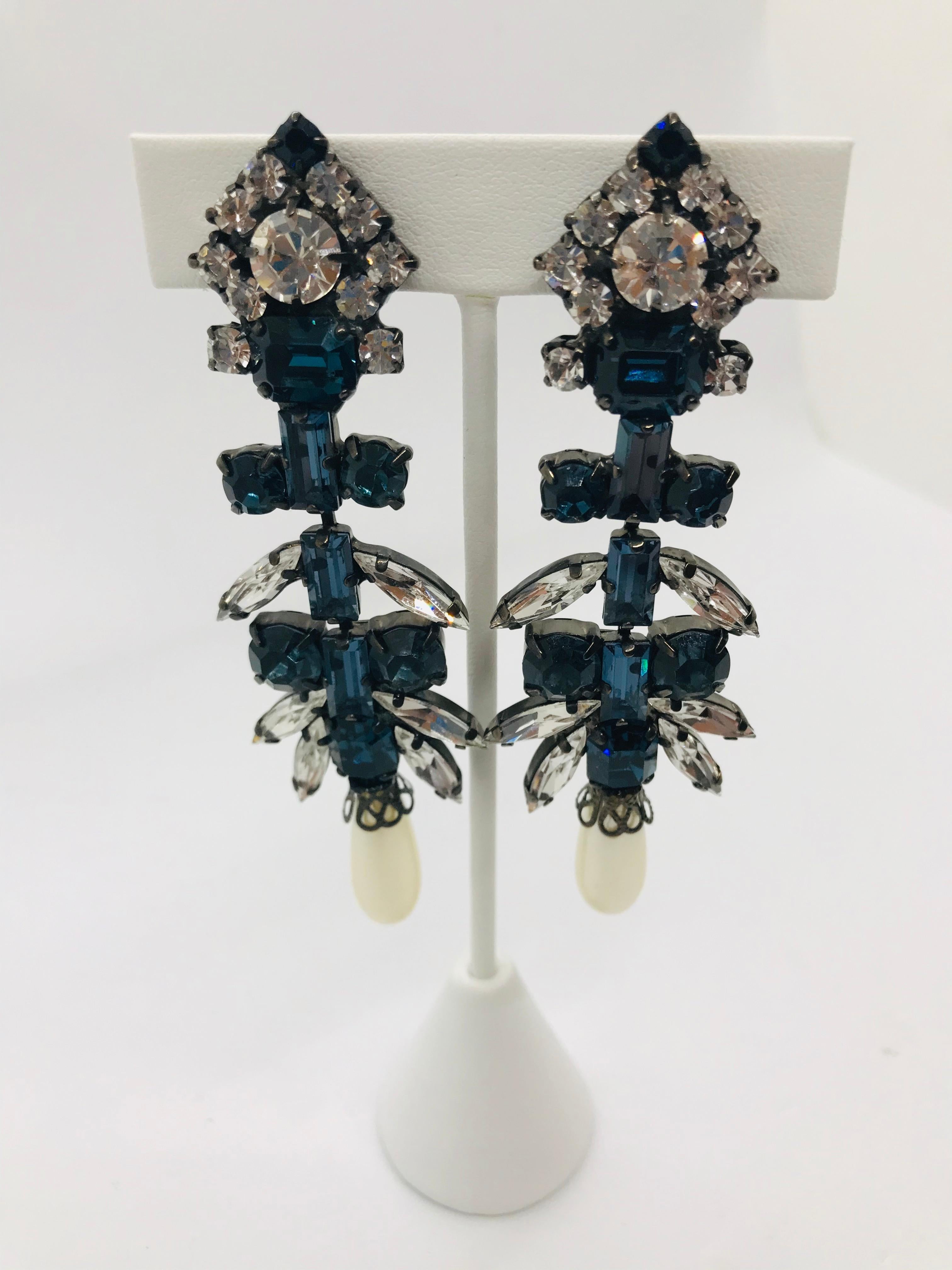 Elegant and classic, these sapphire and clear Austrian crystal chandelier drop earrings feature a 1960s lucite pearl drop.  Montana blue sapphire Austrian crystal baguettes run down the length of these earrings.  These earrings are accented with