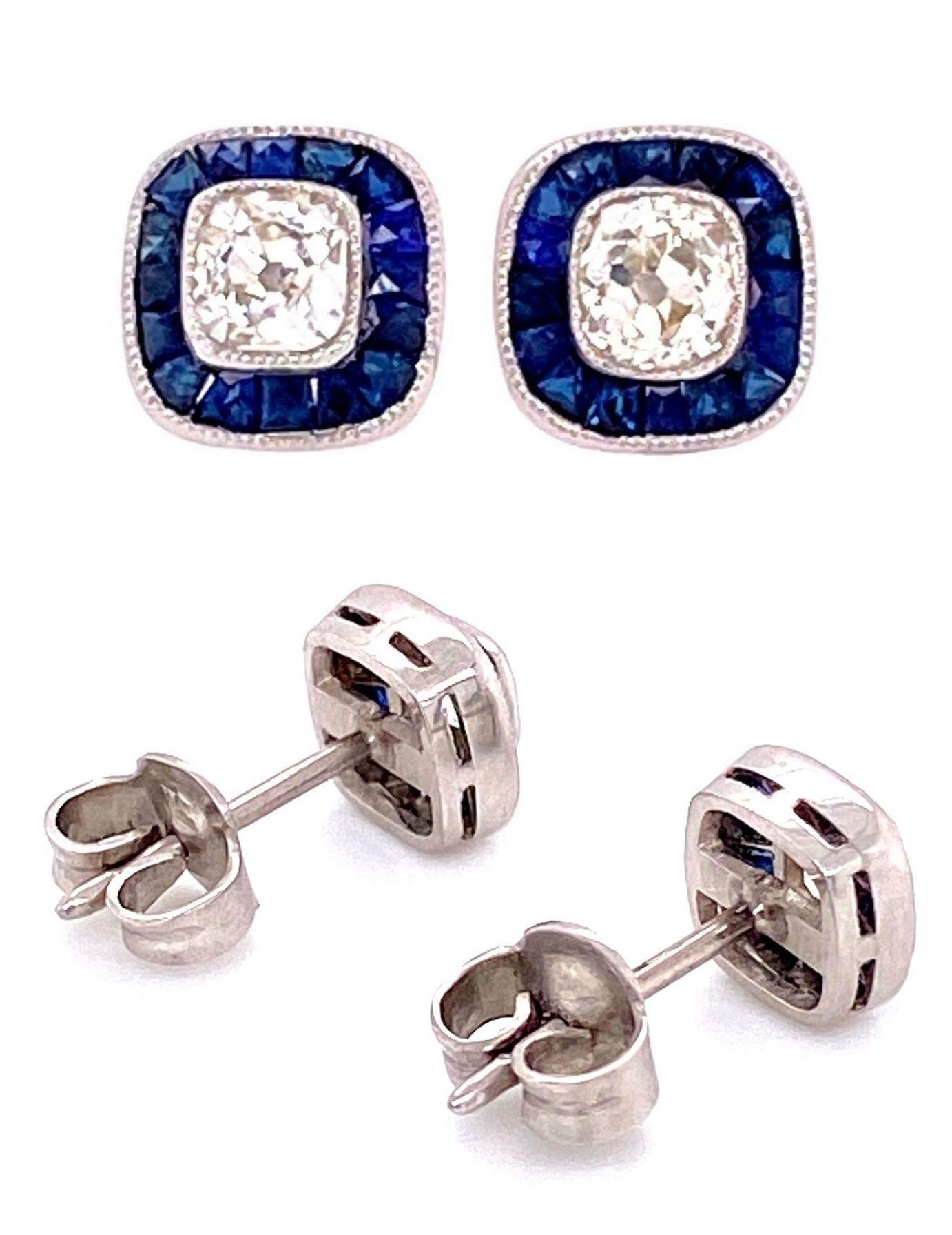 Beautiful and finely detailed Stud Earrings center securely set with Cushion-cut Diamonds, approx. total weight of the 2 Diamonds 0.70 Carats, surrounded by Sapphires, approx. total weight 1.10 Carats. Hand crafted in Platinum. The earrings are in