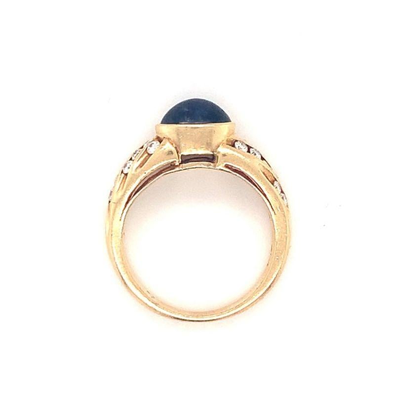 One sapphire and diamond 14K yellow gold ring featuring one bezel set, oval cabochon sapphire weighing 2 ct. and enhanced by 22 round brilliant cut diamonds totaling 0.45 ct. Circa 1970s.

Adorable, vibrant, chic.

Additional information:
Metal: 14K