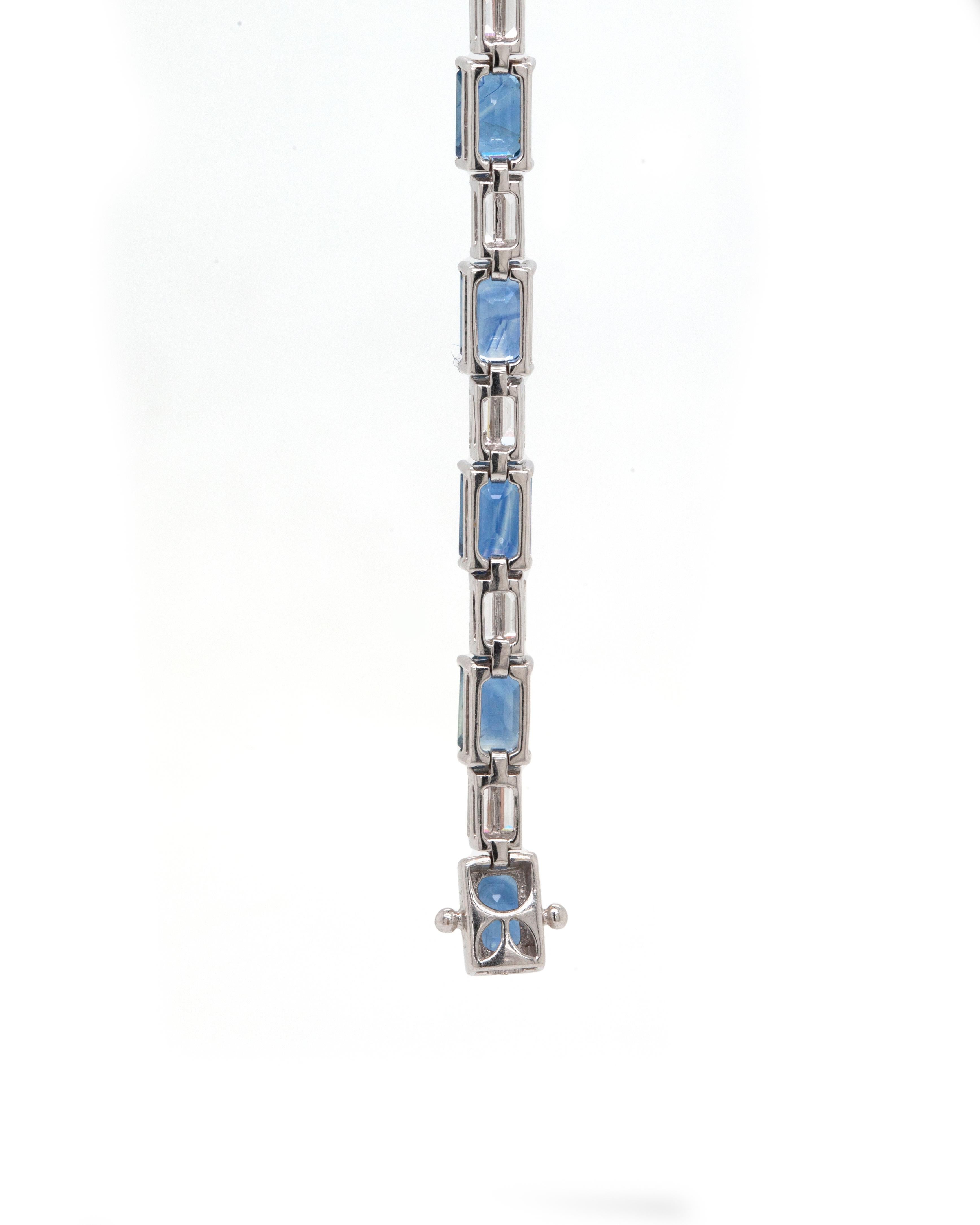 Sleek and elegant, this wonderful 18 carat white gold bracelet features 15 emerald cut blue sapphires all mounted in four claw, open back settings, totalling to an approximate weight of 13.00ct. Alternating with the rich sapphires and creating a