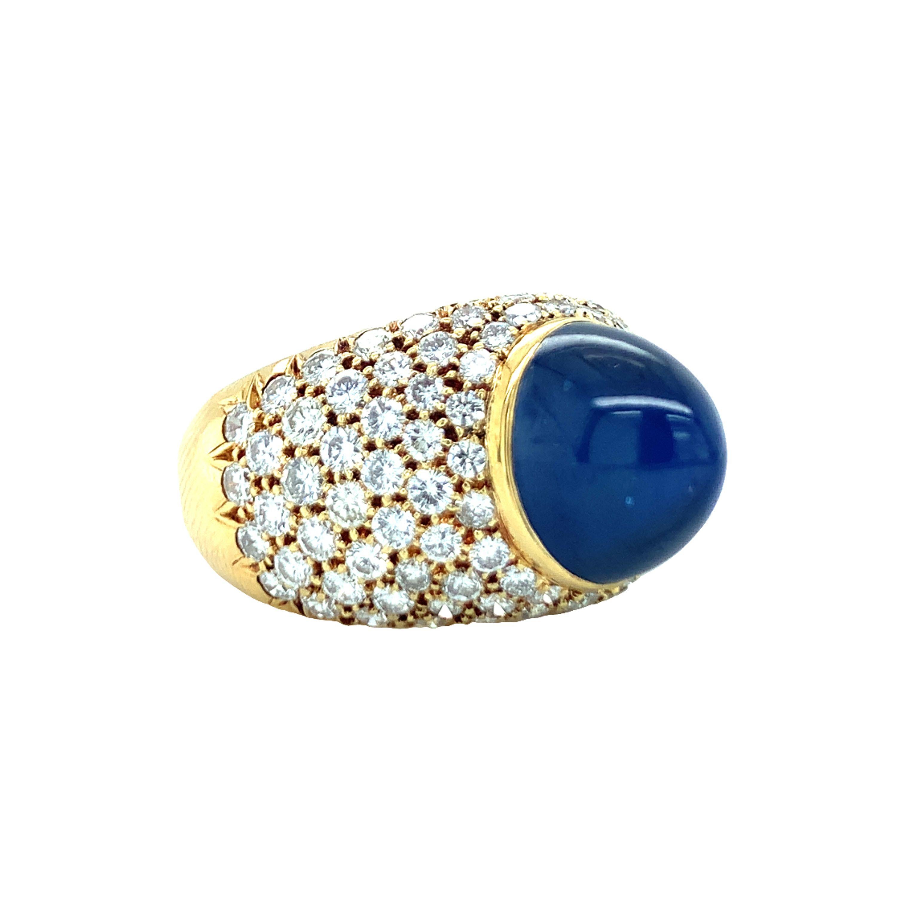One sapphire and diamond 18K yellow gold ring centering one high dimension, oval sugarloaf cabochon cut blue sapphire weighing 10 ct. The ring is further accented by 98 pave set, round brilliant cut diamonds weighing a total of 3 ct. with G color