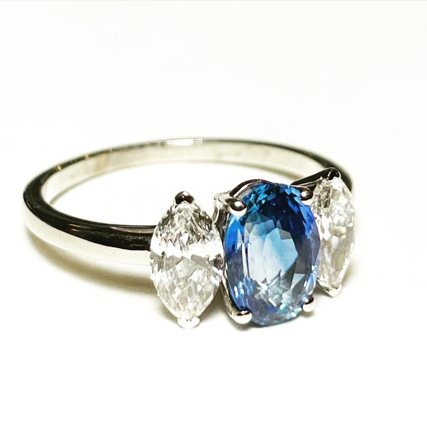 This classic three-stone engagement ring is crafted in 18K white gold.
At the centre of this three stone ring there is a gorgeous oval blue sapphire and sat either side is a bright sparkling navette diamond. The oval cut sapphire weights 1.65 carat