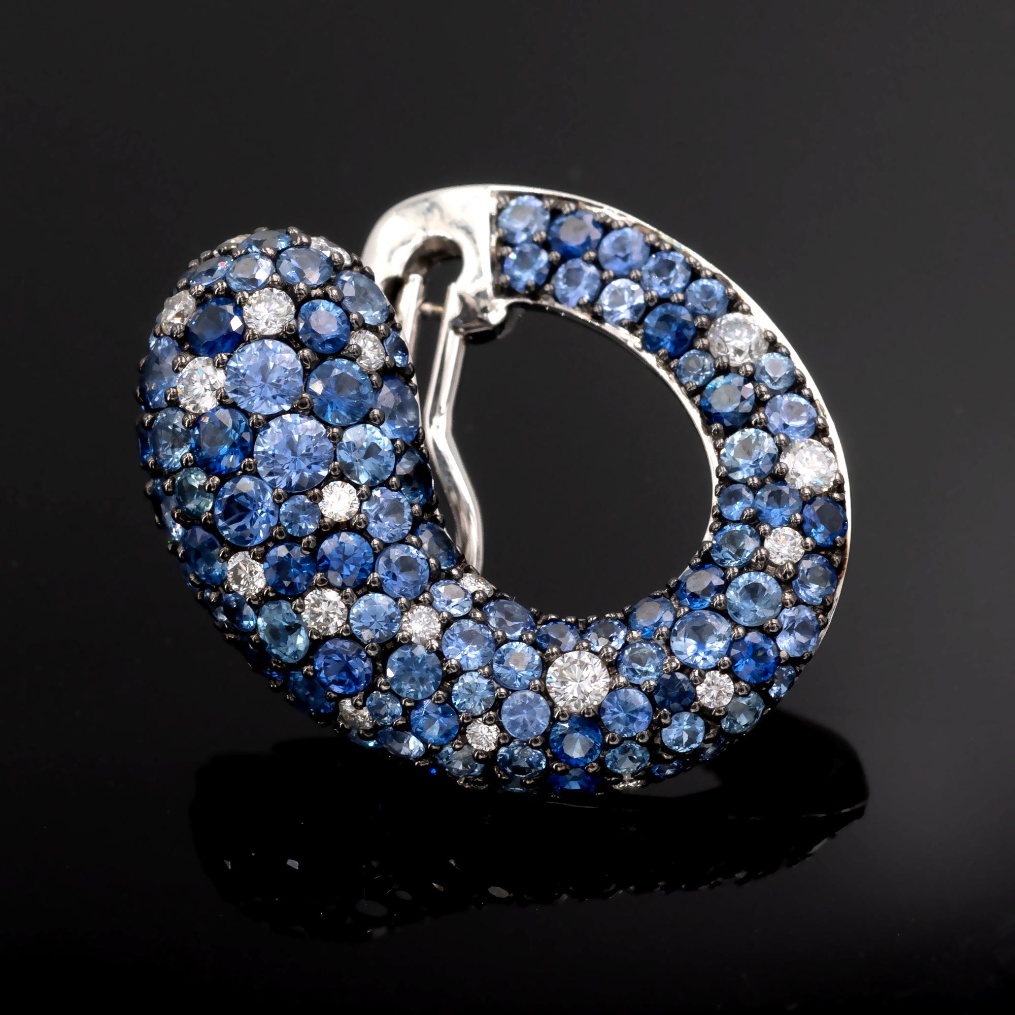 Lovely hoop shaped earrings earrings tightly tiled with sapphires and diamonds. The lively brilliant cut sapphires being of different shades of blue create a fascinating gradient highlighted with top quality diamonds savvily sprinkled over it.
The