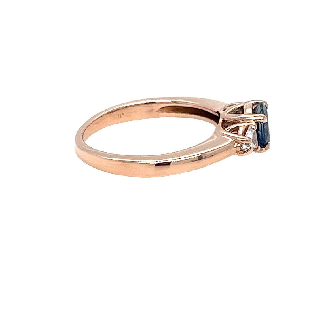 Anello a 3 pietre in oro rosa 14 carati con uno zaffiro rotondo da 0,83 carati e 2 diamanti taglio brillante di purezza VS e colore H per un totale di 0,20 carati. Taglia 6; Include un servizio di dimensionamento prima della spedizione, su