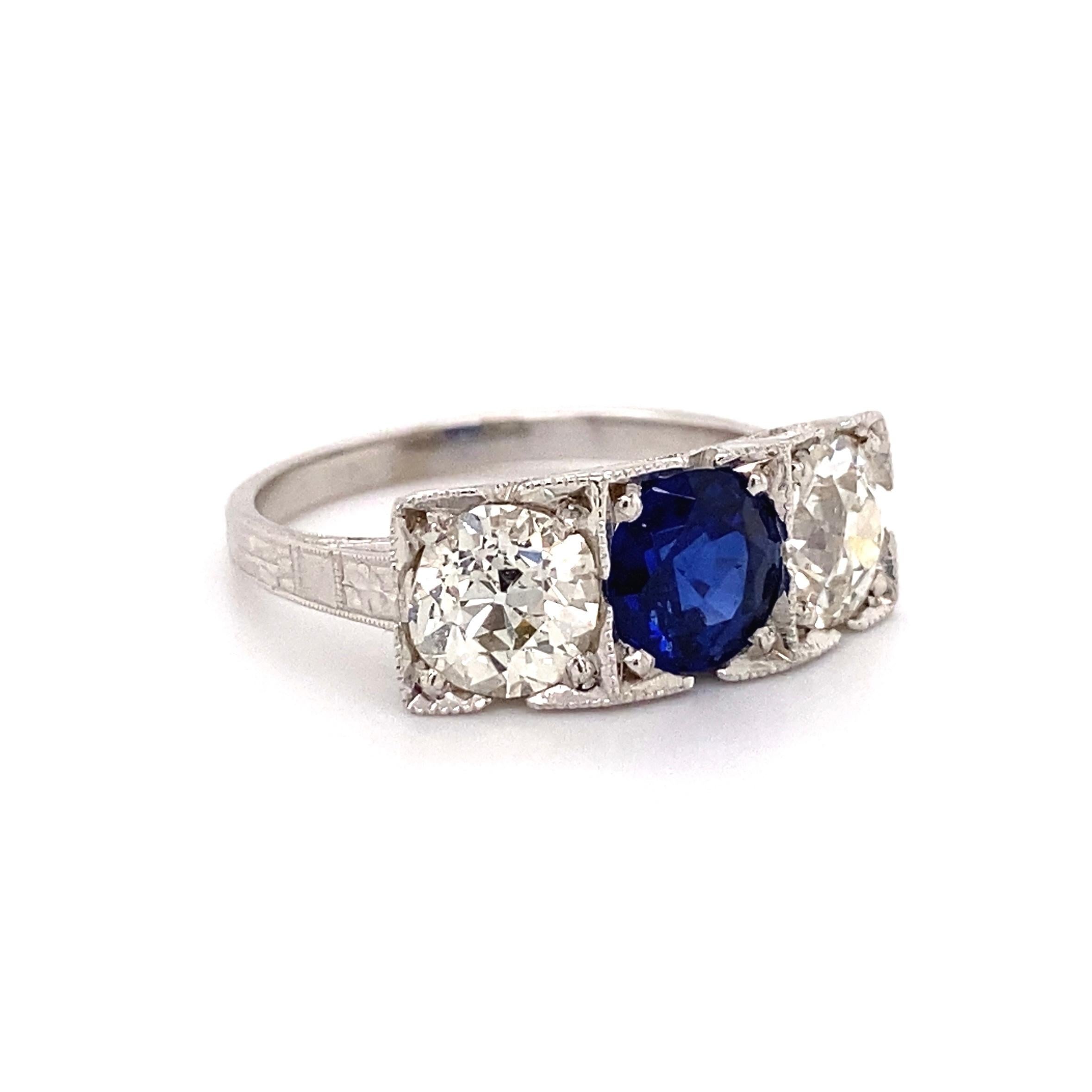 Simply Beautiful! Finely crafted Three Stone Sapphire and Diamond Ring. Centering a Hand set securely nestled Blue Sapphire, eye clean and bright, weighing approx. 1.40 Carat with a Diamond on either side; approx. 0.97 Carat and 1.00 Carat.; I-J
