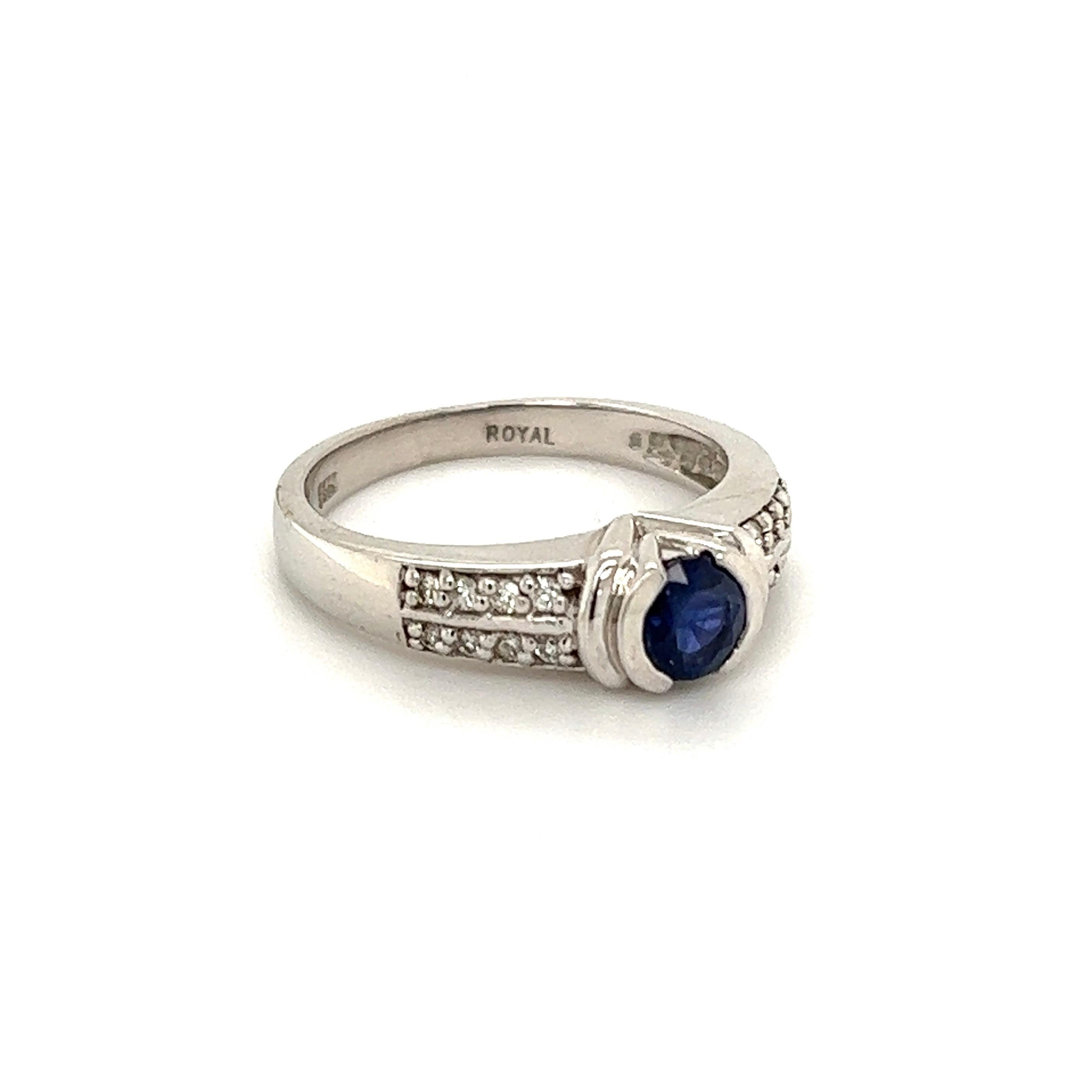 Simply Beautiful! Finely Detailed Blue Sapphire and Diamond Gold Ring. Center securely nestled with a Hand set 0.60 Carat Round Sapphire, accented by Diamonds, approx. 0.10tcw. Hand crafted 14K White Gold mounting. Marked: 14K