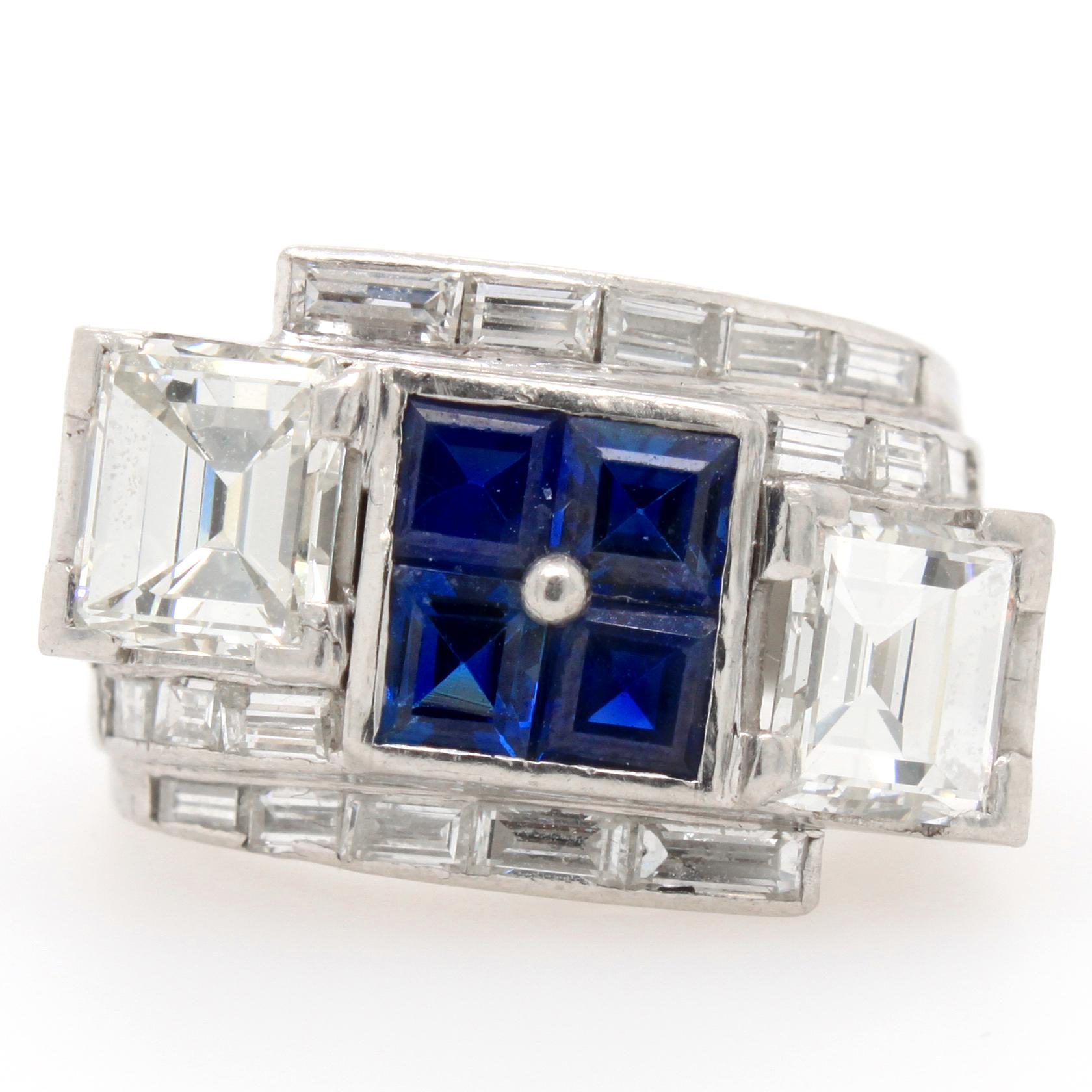 An Art Deco ring with sapphires and diamonds in platinum, ca. 1930s. The four sapphire carrés in the centre are flanked by two bigger square cut diamonds on the border of the top and bottom side. The profile of the ring shows a beautiful design with