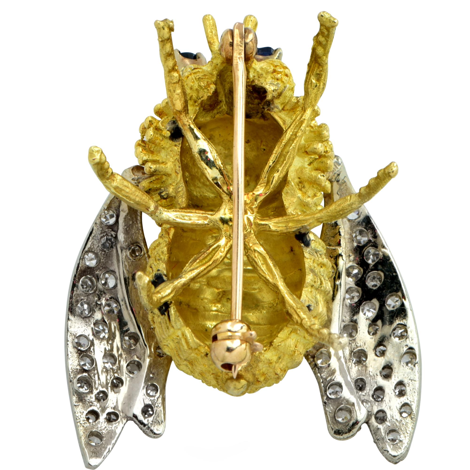 This stunning Bee brooch pin is intricately crafted in 18 Karat yellow gold with wings adorned with 53 single cut diamonds weighing approximately .60 carats total weight , J color and SI clarity and two sapphire eyes weighing approximately .10