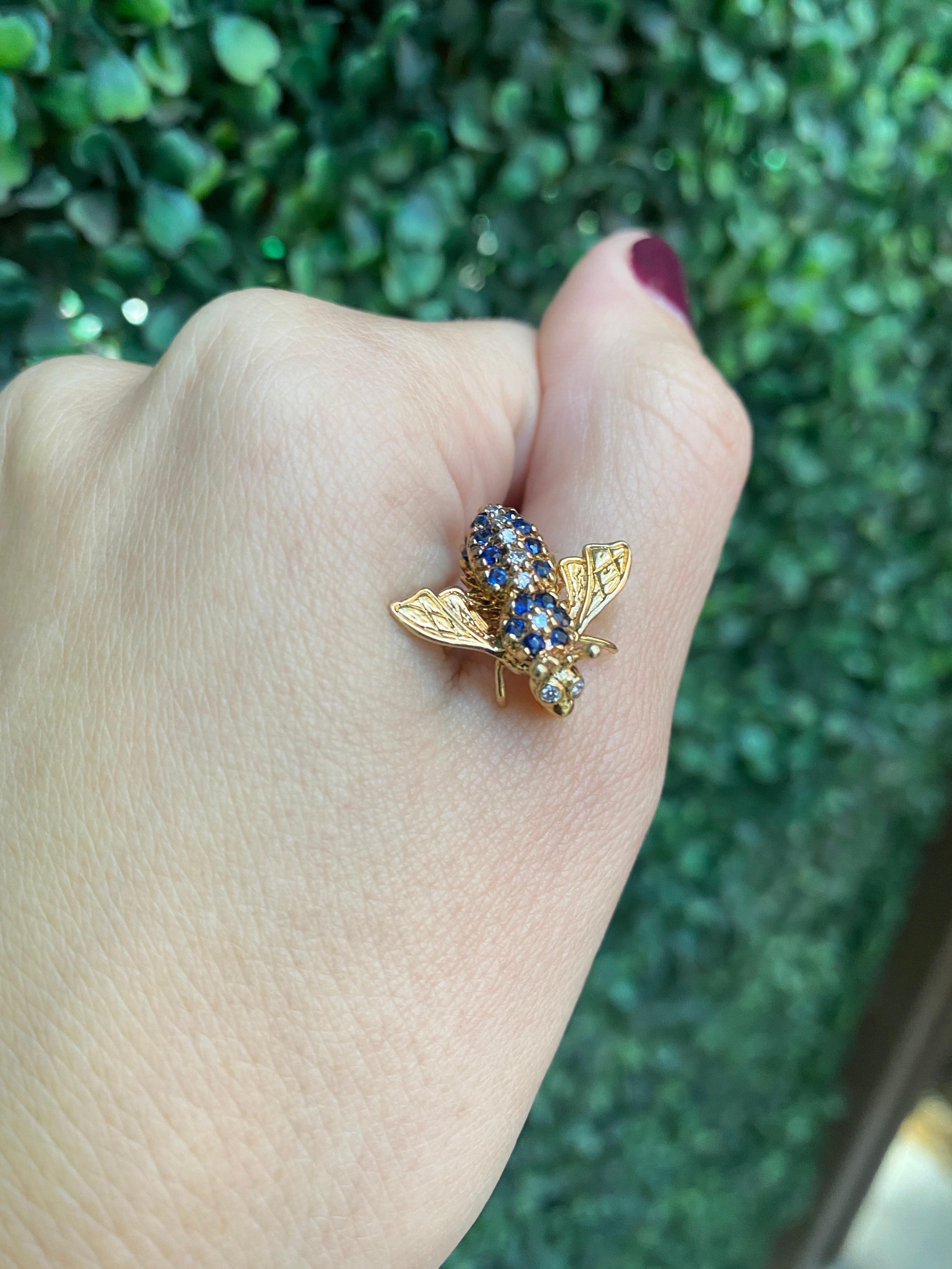 These petite but mighty bumble bee pin features 0.15 carat total weight in round blue sapphires and 0.06 carat total weight in round diamonds set in 14 karat yellow gold. 
Measurements: Approximately 19.50mm x 20mm
Condition: Excellent. No visible