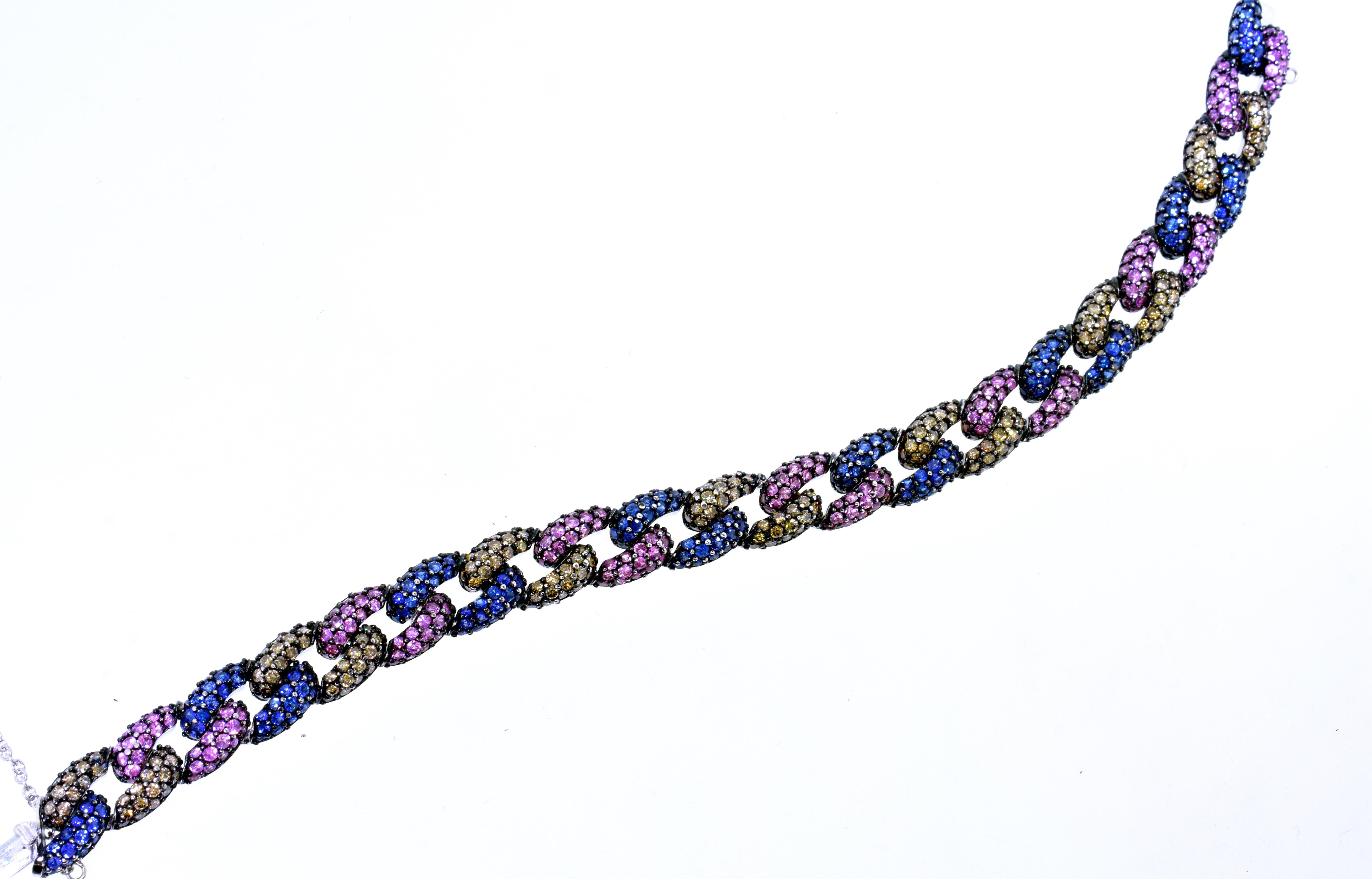 Sapphires, both blue and pink, and champagne colored diamonds are set in a contemporary link bracelet.  There are 250 bead set brilliant cut natural blue sapphires weighing an estimated total of 5.0 cts.  There is  250 natural pink sapphires also
