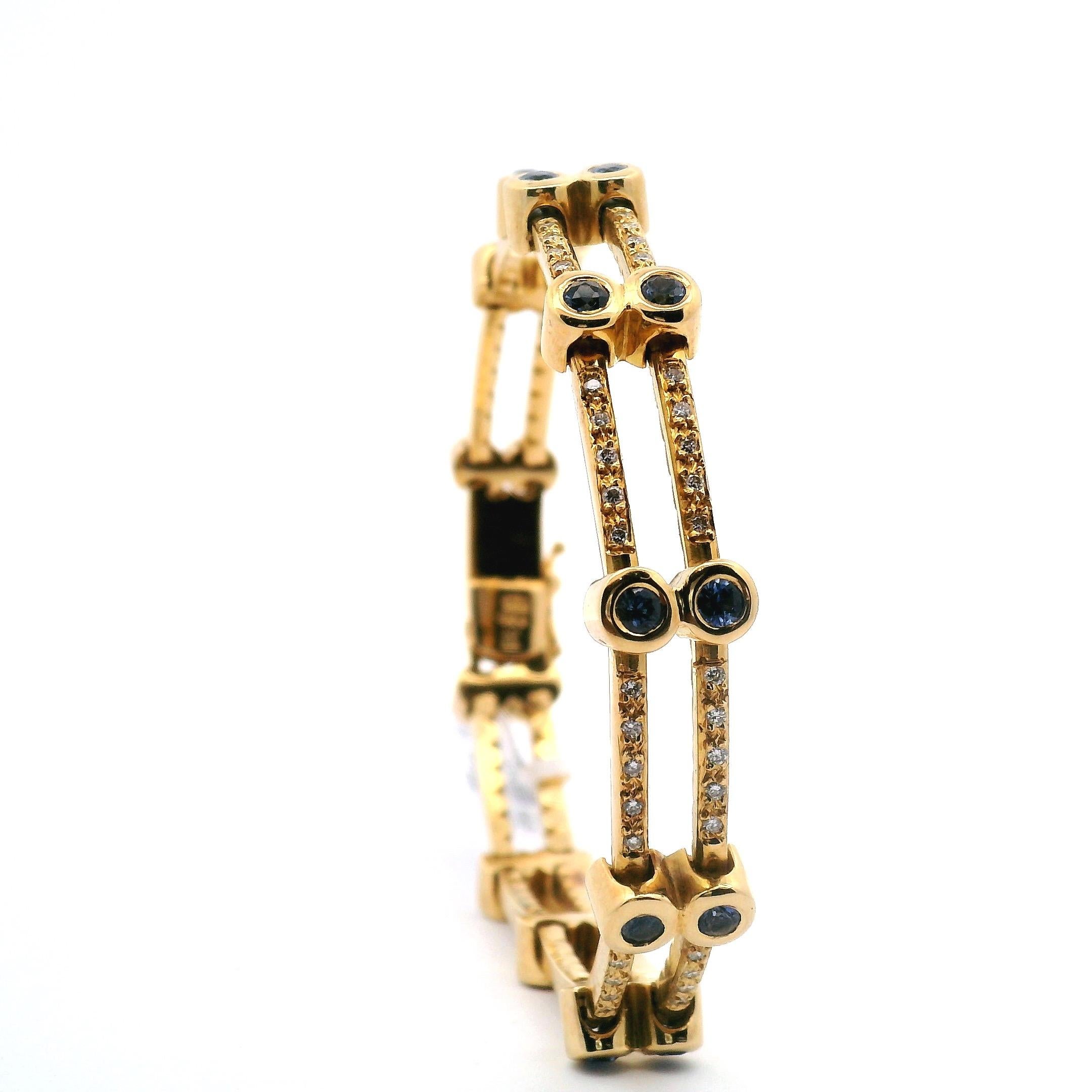 Bracciale a maglie d'oro. Due fili d'oro con zaffiri incastonati e cinque diamanti rotondi incastonati tra gli zaffiri.
composto da:

110 diamanti rotondi di circa .77cttw.
22 zaffiri rotondi di circa 1,76 carati. 

Oro giallo 18k 33,6 grammi 